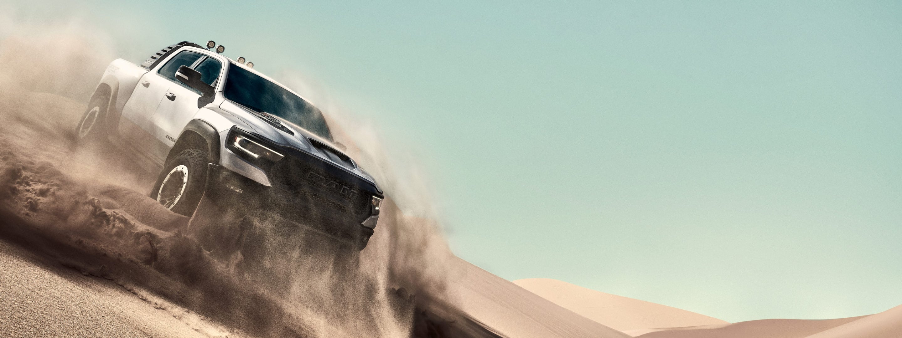 The 2021 Ram 1500 TRX being driven over a sand dune.