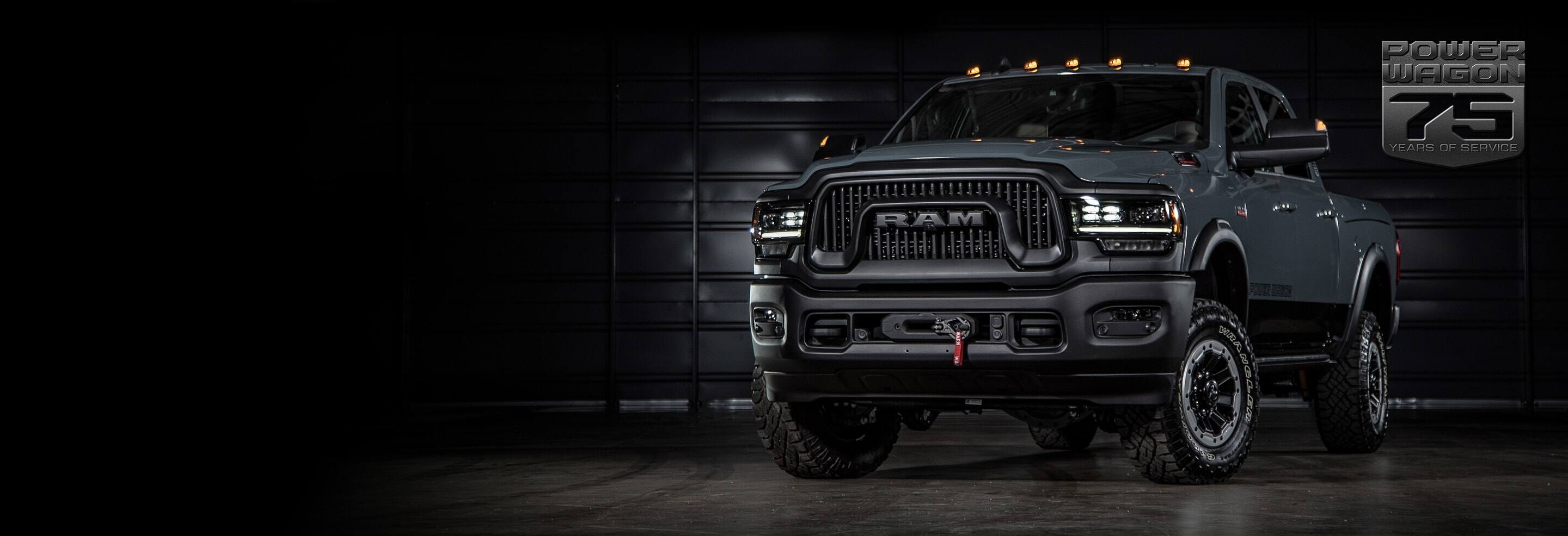 The 2021 Ram 2500 Power Wagon 75th Anniversary Edition parked in a darkened industrial garage. The Power Wagon 75 Years of Service logo.