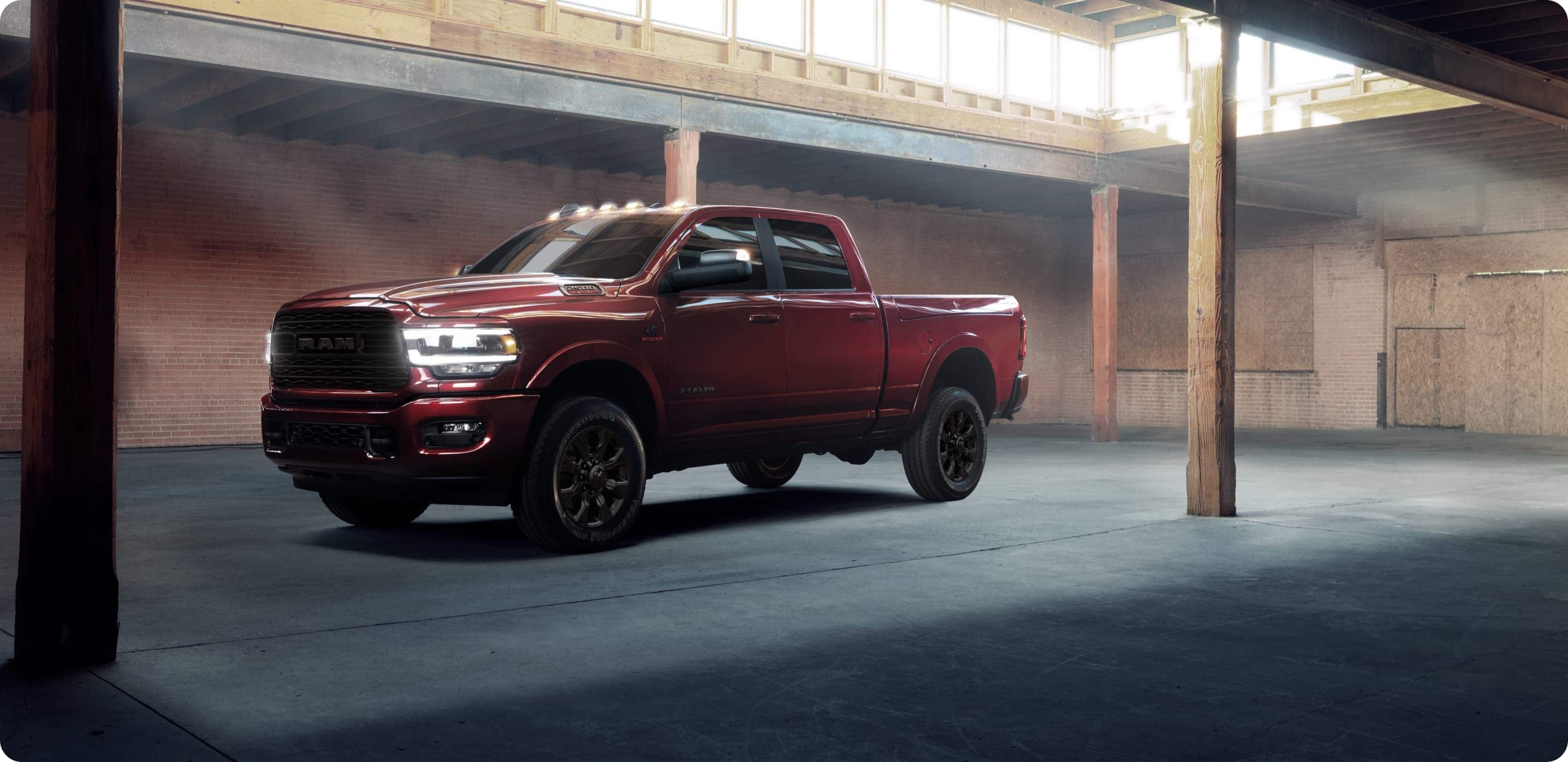 Display A red 2021 Ram 2500 Limited Night Edition parked in a parking structure with its lights on.