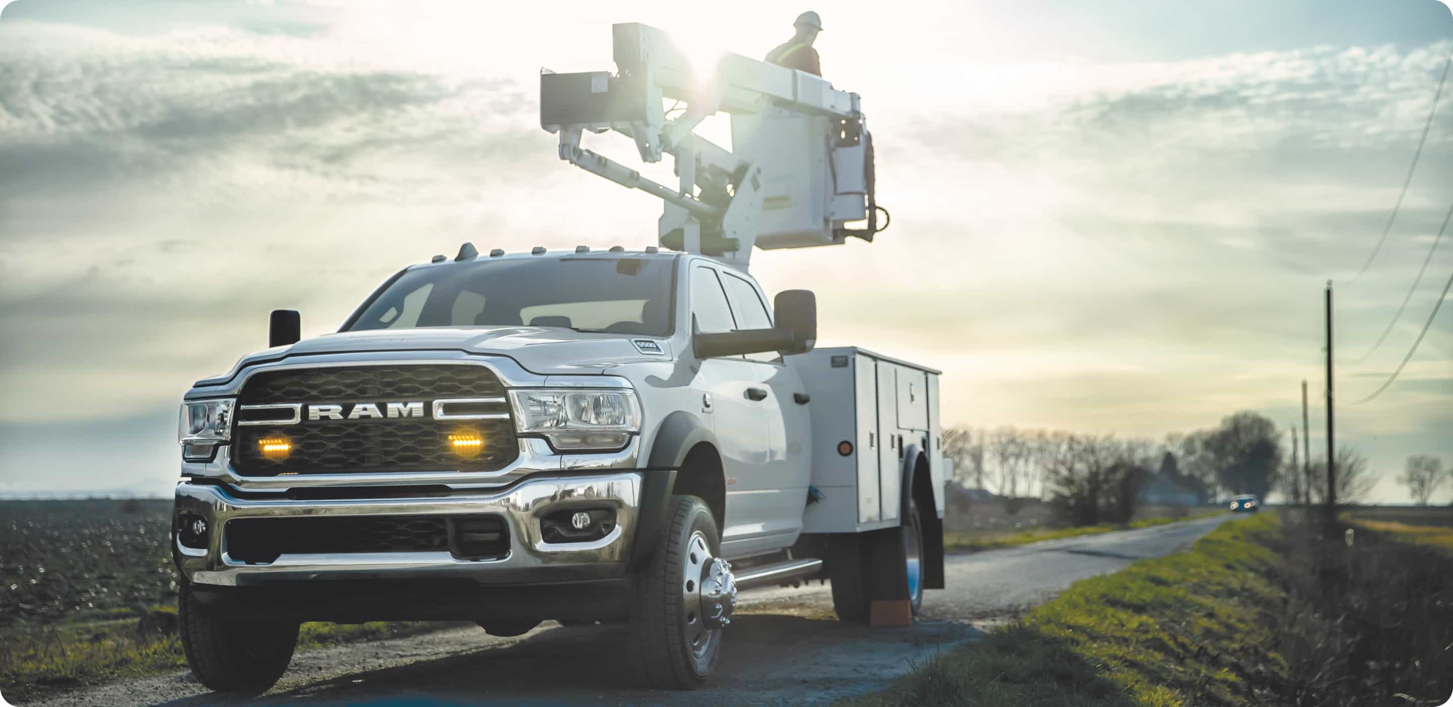 Display The 2021 Ram Chassis Cab with a cherry picker upfit with a worker in the bucket.