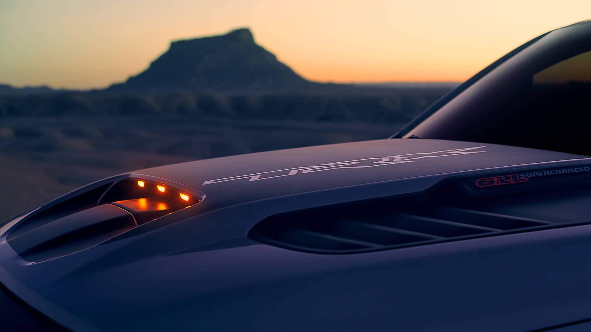 A close-up of the red lights on the center dome of the 2021 Ram 1500 TRX hood.