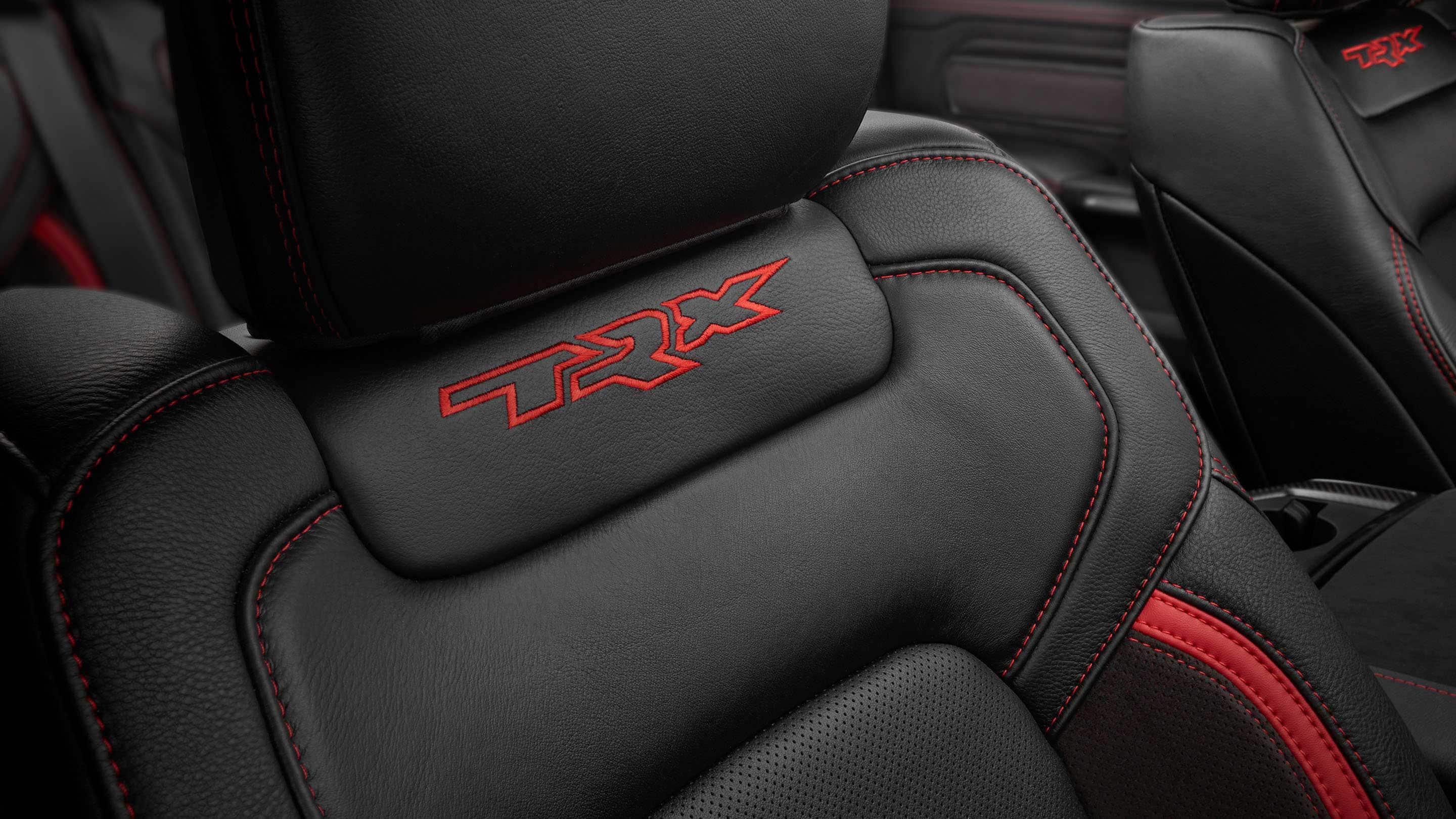A close-up shot of the embroidered TRX logo on the front passenger seatback in the 2021 Ram 1500 TRX.