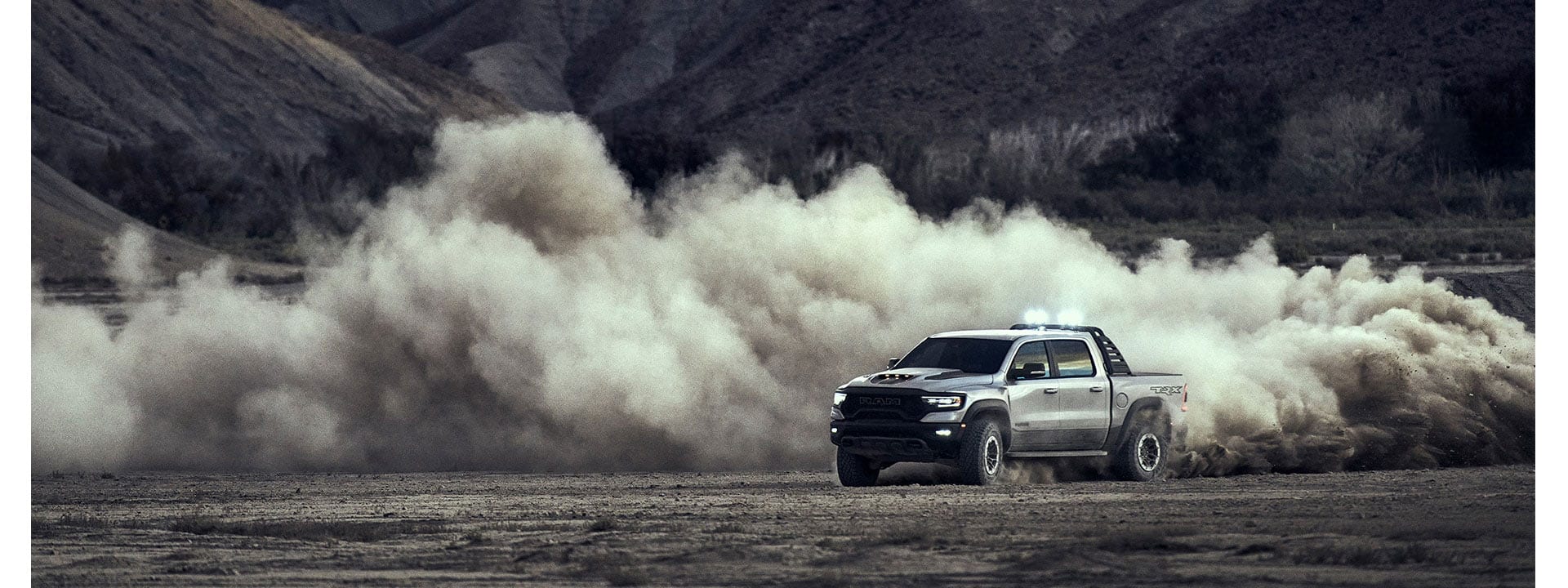 The 2021 Ram 1500 TRX just after a turn, creating a circular dust cloud in its wake.