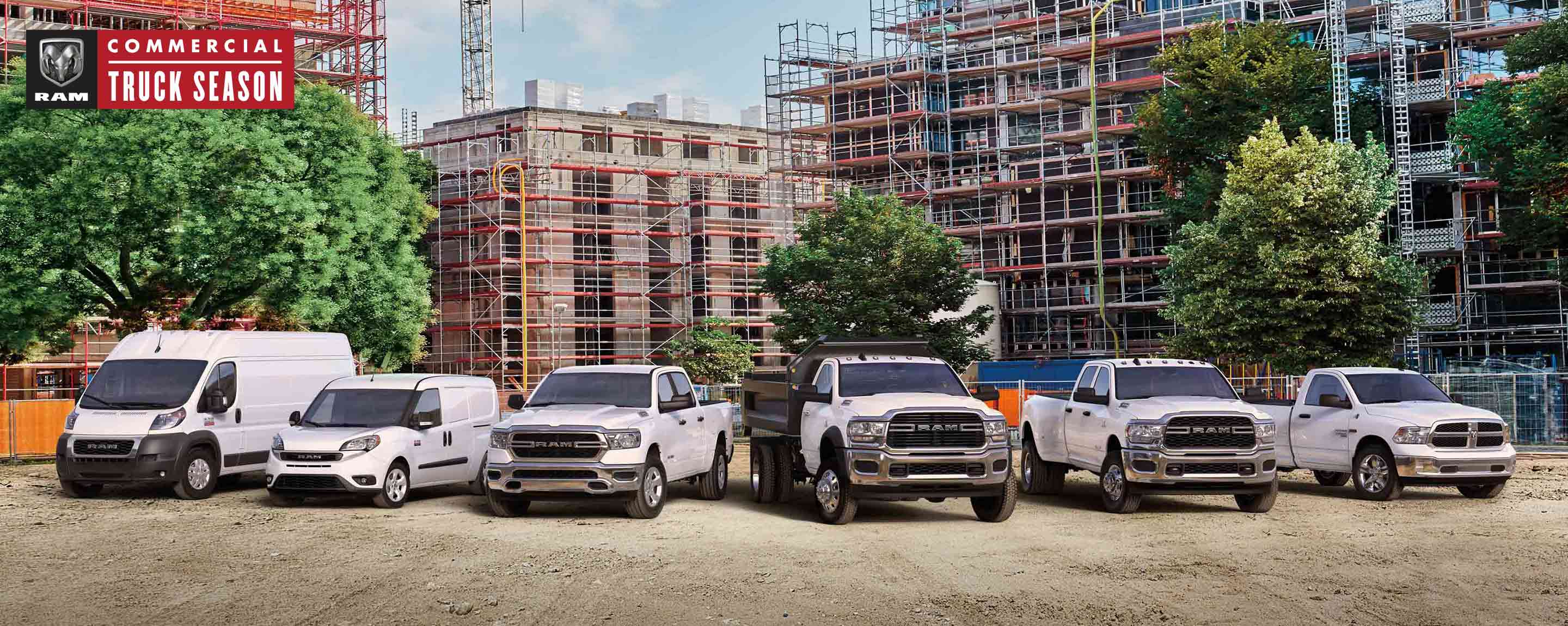 Ram Commercial Truck season. The 2021 Ram lineup parked at a massive commercial construction site. From left to right: a Ram ProMaster High Roof, Ram ProMaster City Cargo Van, Ram 1500, Ram 5500 Chassis Cab with dump body, Ram 3500 and Ram 1500 Classic.