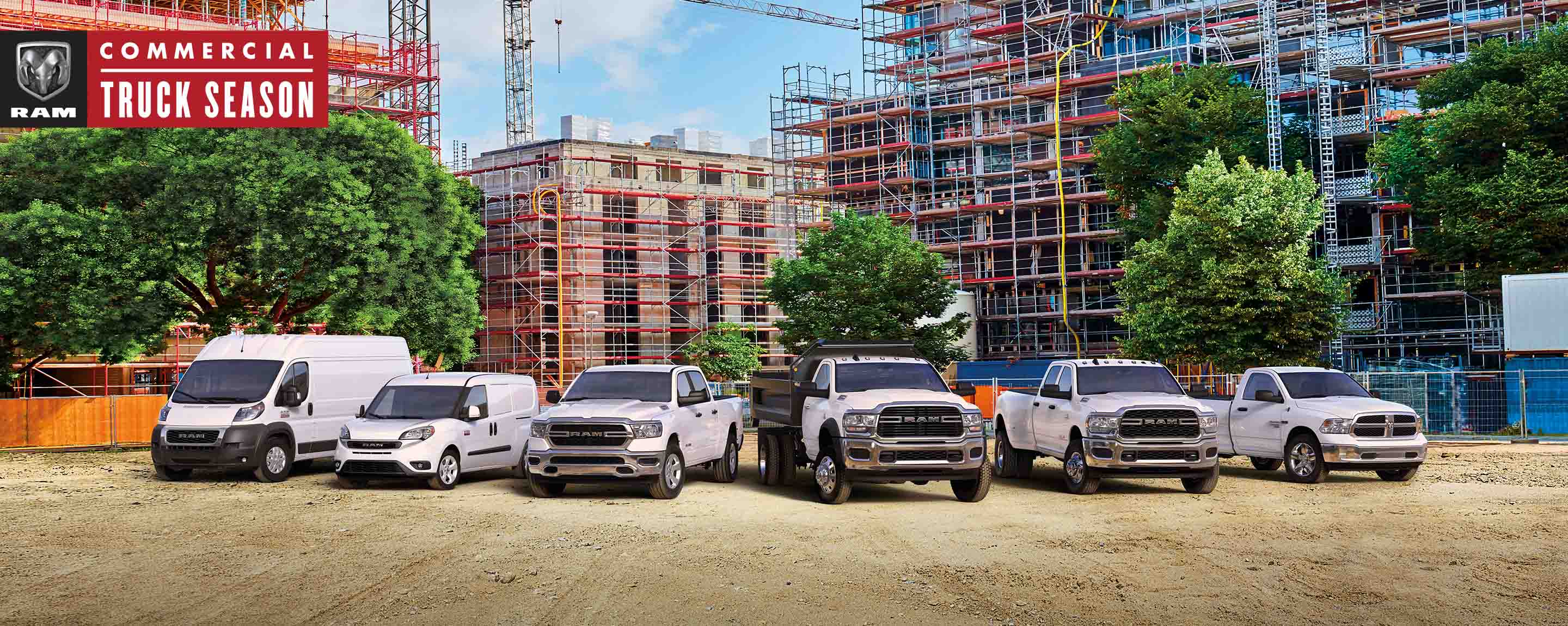 Ram Commercial Truck season. The 2021 Ram lineup parked at a massive commercial construction site. From left to right: a Ram ProMaster High Roof, Ram ProMaster City Cargo Van, Ram 1500, Ram 5500 Chassis Cab with dump body, Ram 3500 and Ram 1500 Classic.