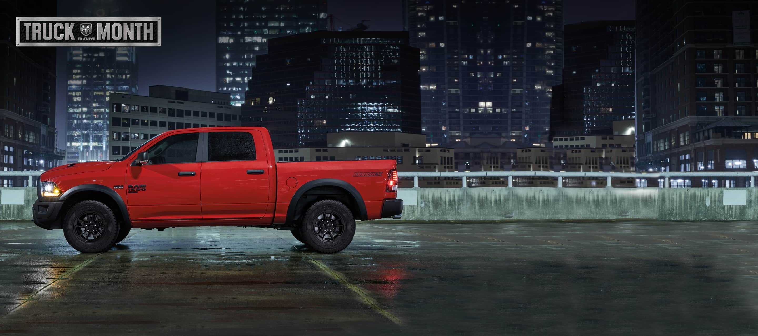 A side profile of a 2022 Ram 1500 Classic Warlock Crew Cab 4x2 with 5'7" box against a backdrop of skyscrapers at night. The Ram Truck Month logo.