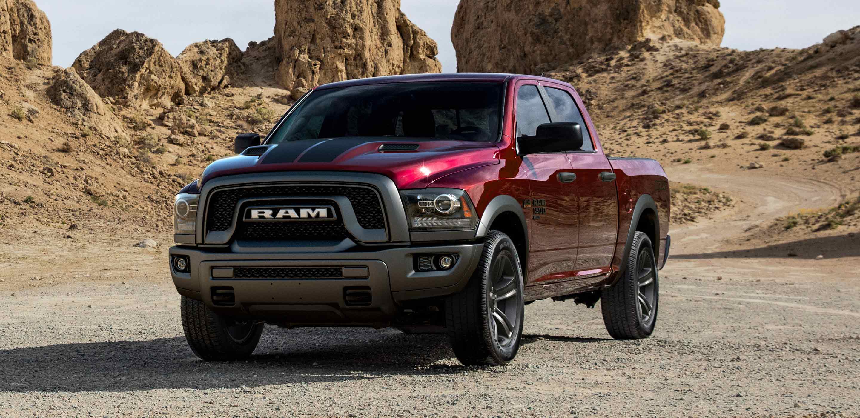 Display The 2022 Ram 1500 Classic parked on a twisting desert road with rocky outcroppings in the distance.