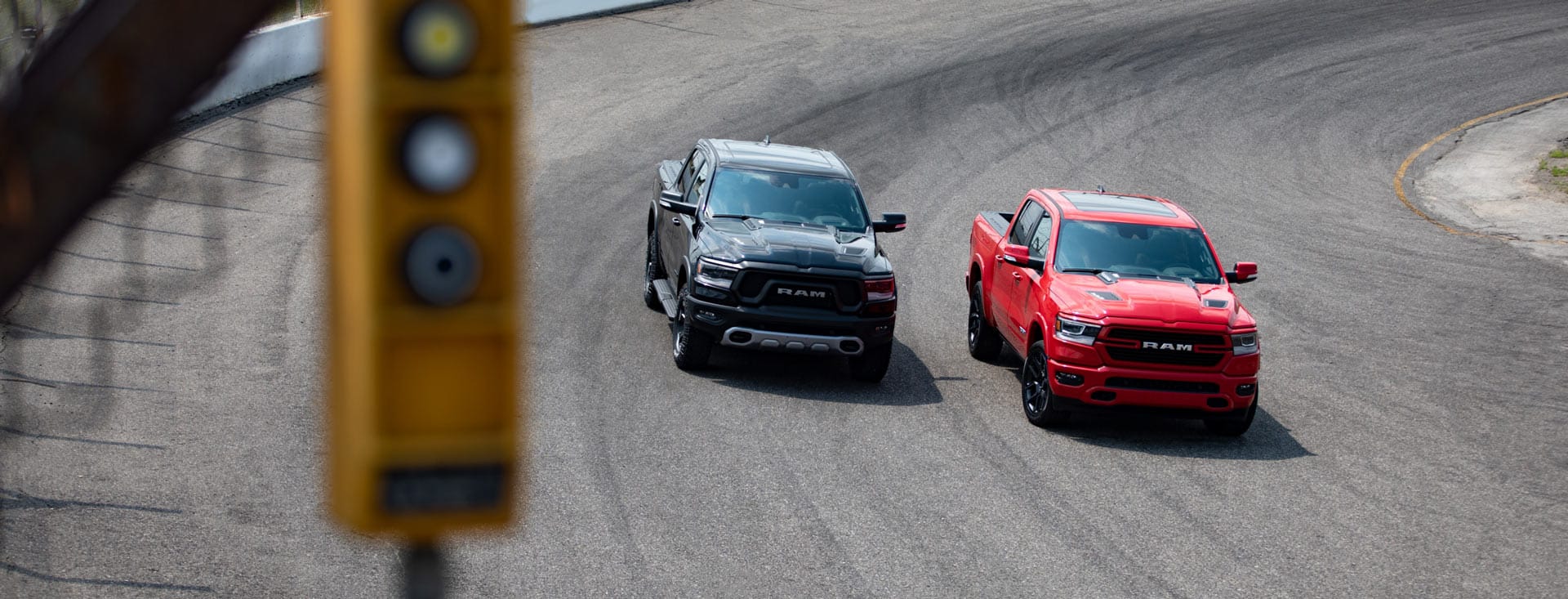 The 2022 Ram 1500 Laramie G/T and Rebel GT rounding a curve on a racetrack.