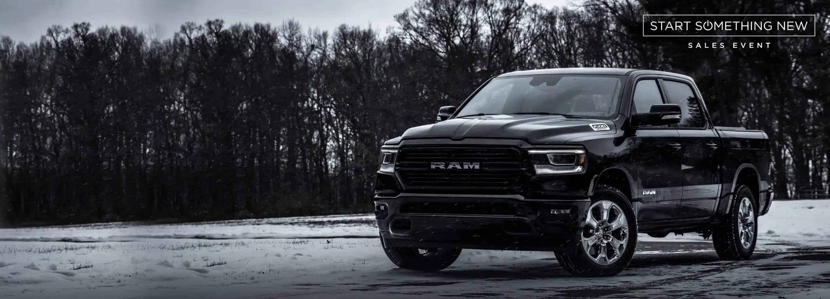 A 2022 Ram 1500 Big Horn 4x4 parked on a snow-covered clearing in the woods. The Start Something New Sales Event logo.