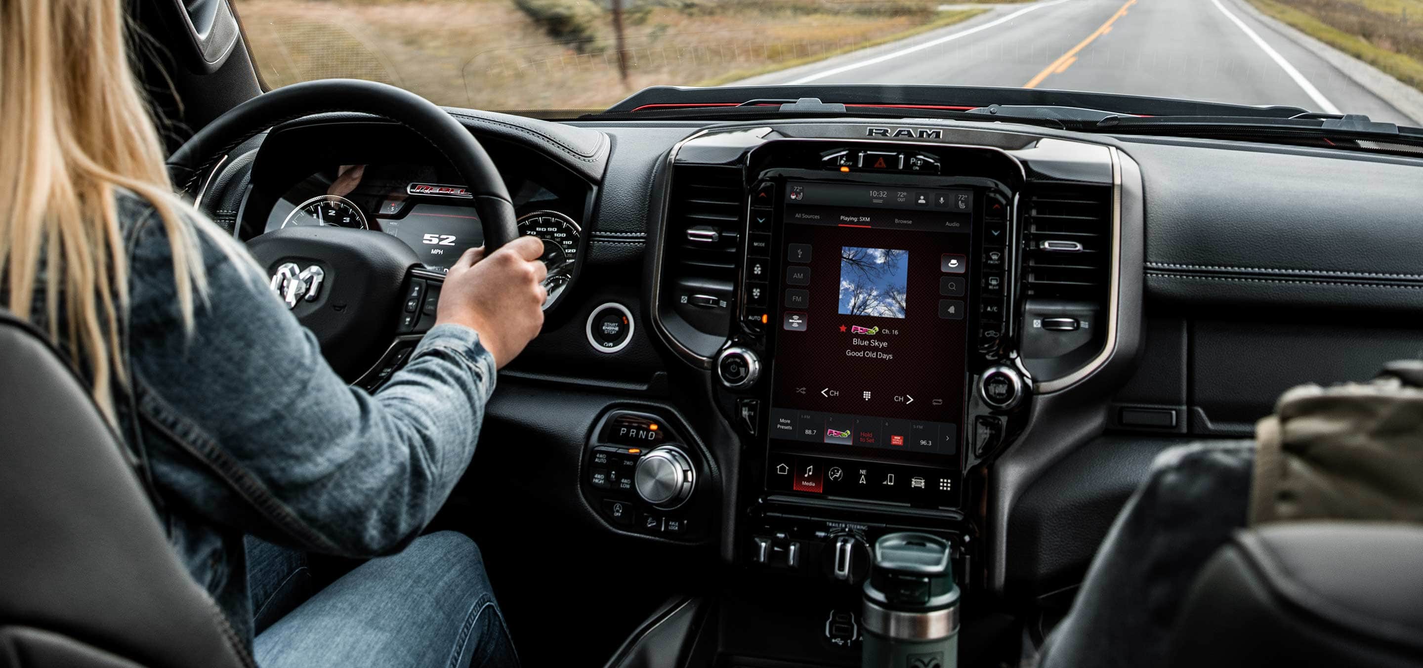 A driver and passenger in the 2022 Ram 1500 with the touchscreen displaying a route map.