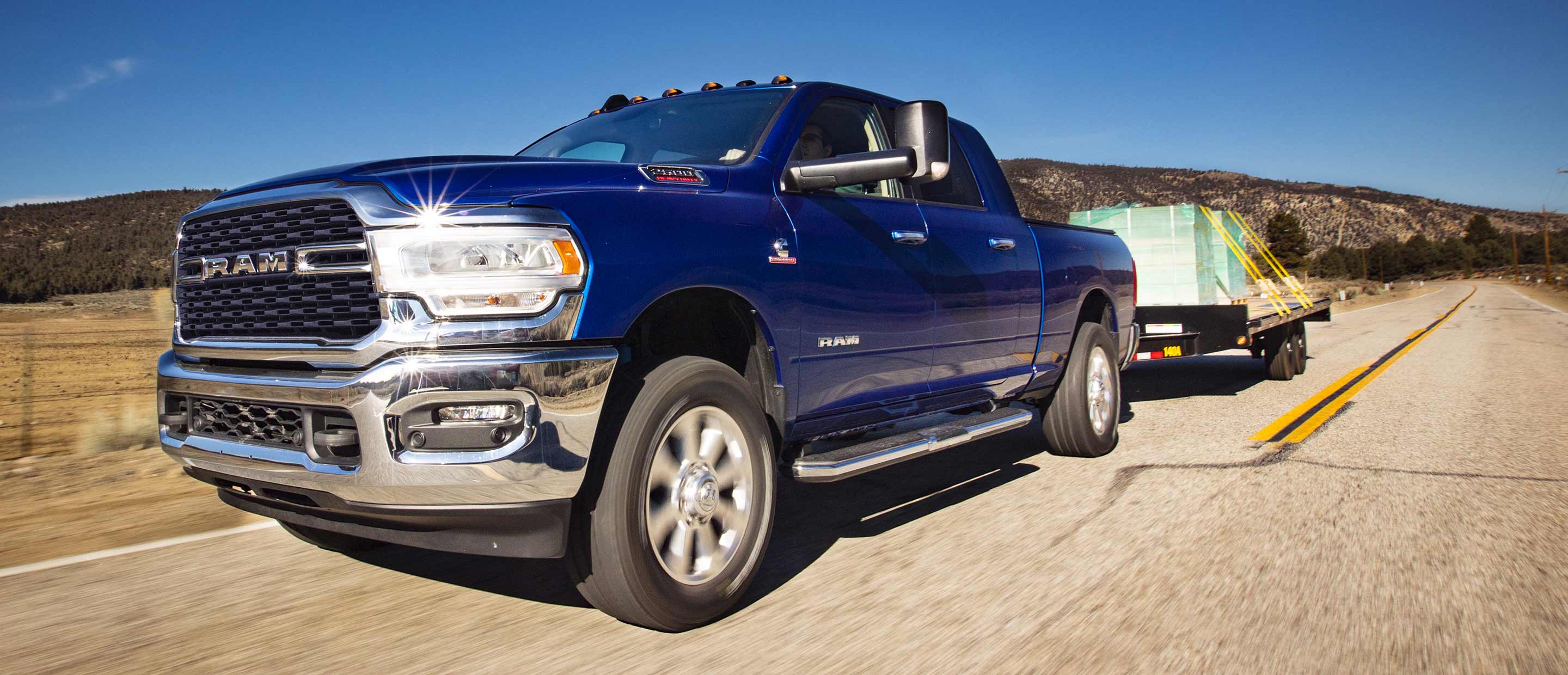 The 2022 Ram 2500 towing a flatbed loaded with bricks.
