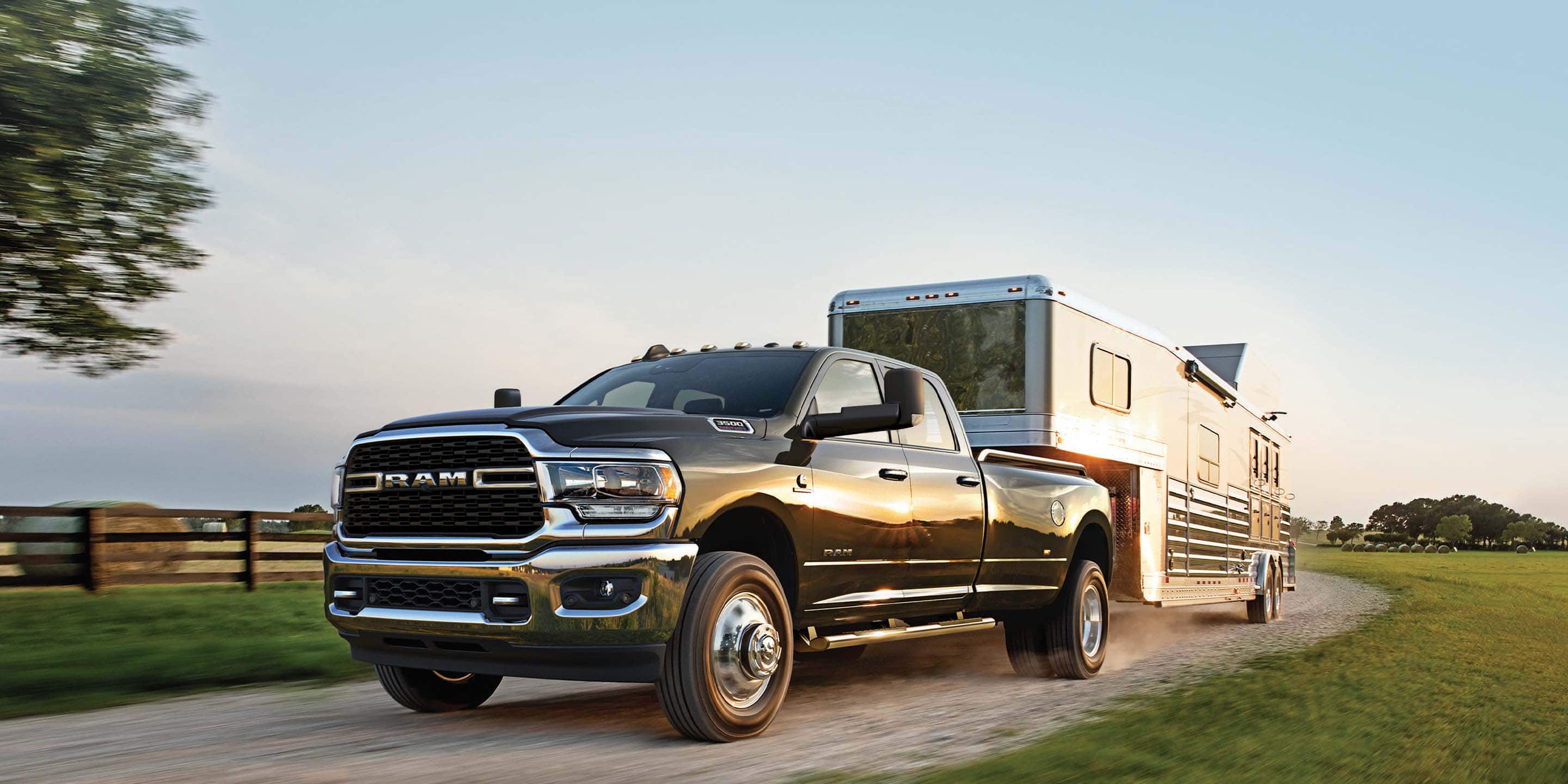 The 2022 Ram 3500 Big Horn towing an RV on a country road.