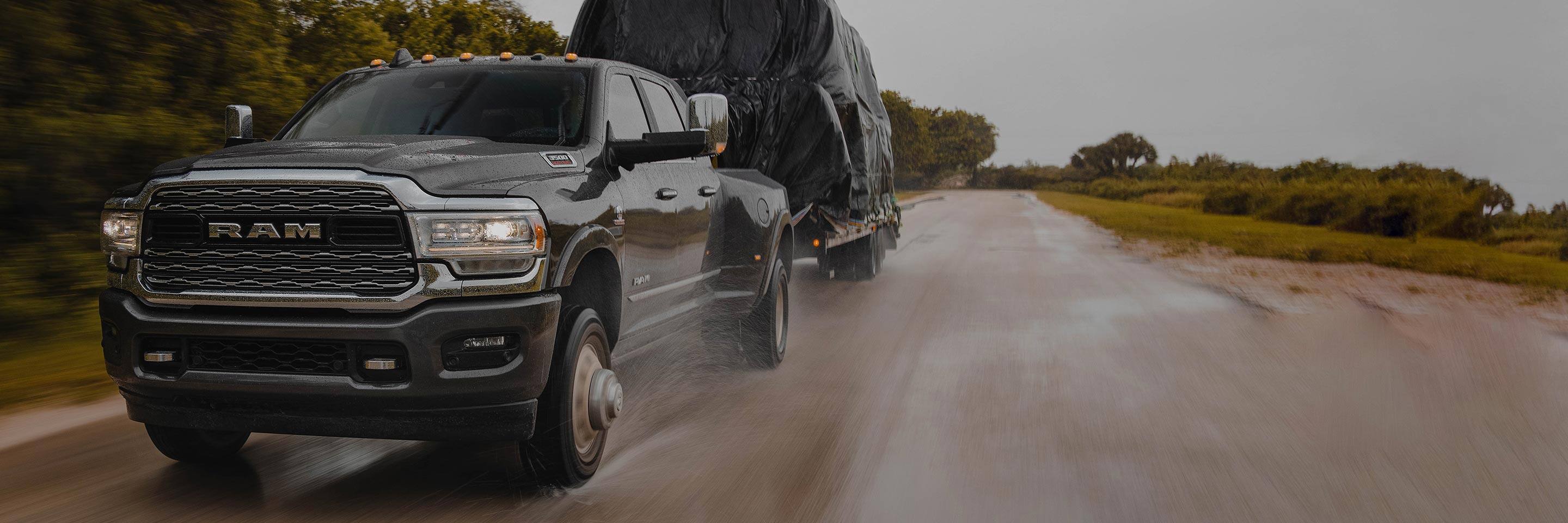 The 2022 Ram 3500 towing a covered load in the rain.