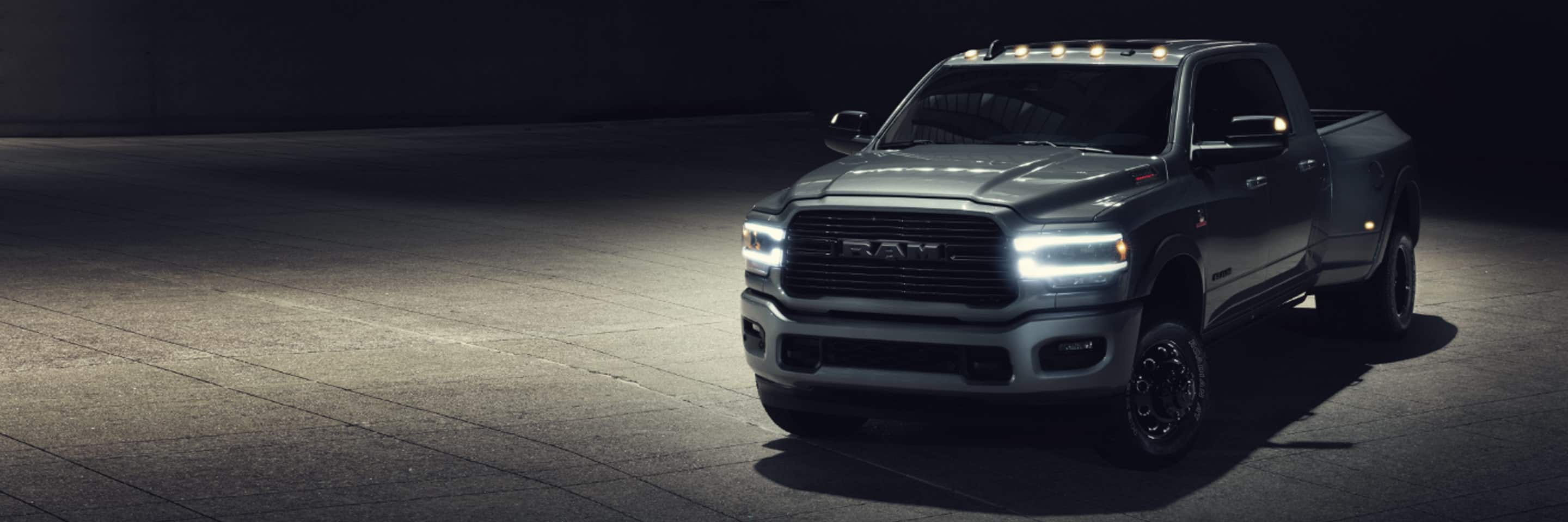 The 2022 Ram 3500 at night with headlamps and Ram Bar lit.