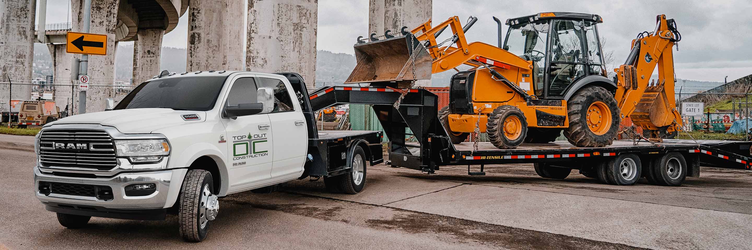 The 2022 Ram Chassis Cab towing a flatbed trailer loaded with an excavator.