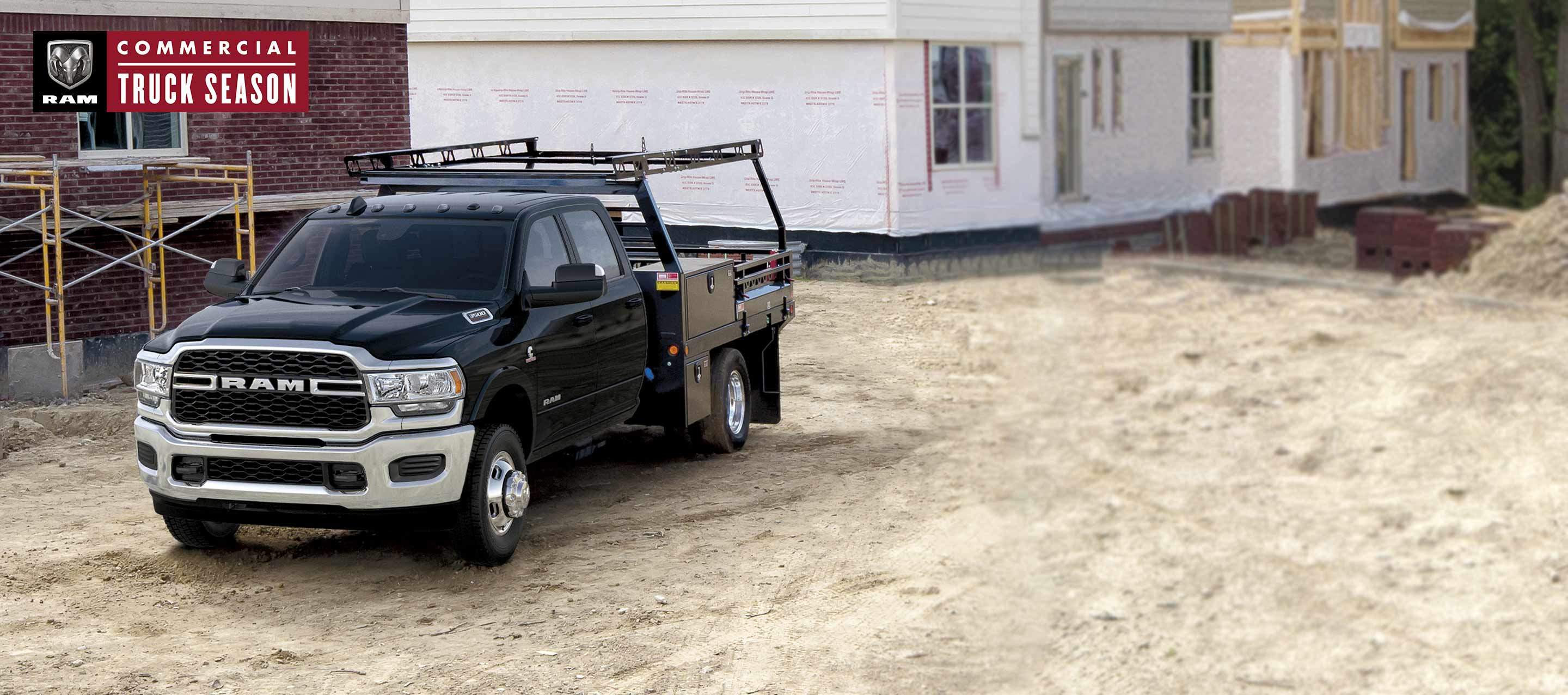 A black 2022 Ram 3500 Tradesman Chassis Cab 4x4 Crew Cab with service upfit, parked at a residential construction site. Ram Commercial Truck Season.
