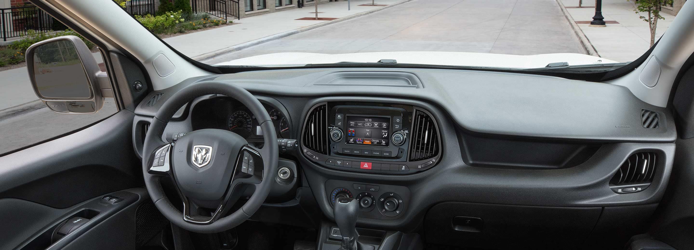 The interior of the 2022 Ram ProMaster City, focusing on the steering wheel, dashboard, touchscreen and shift controls.