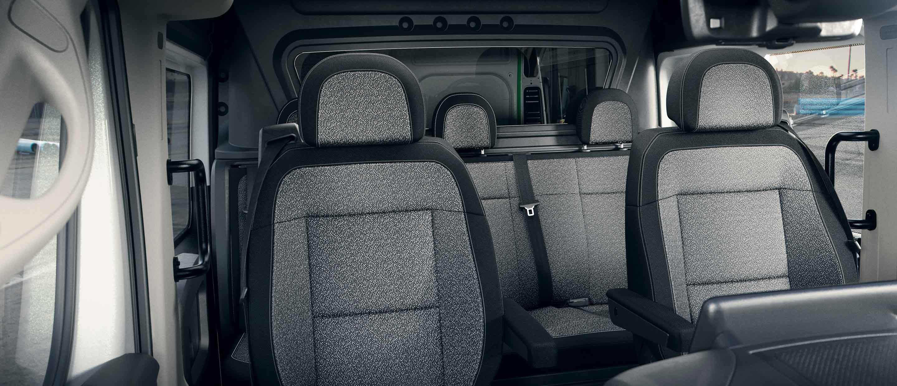 The front bucket seats and rear bench seat in the 2022 Ram ProMaster Crew Van.
