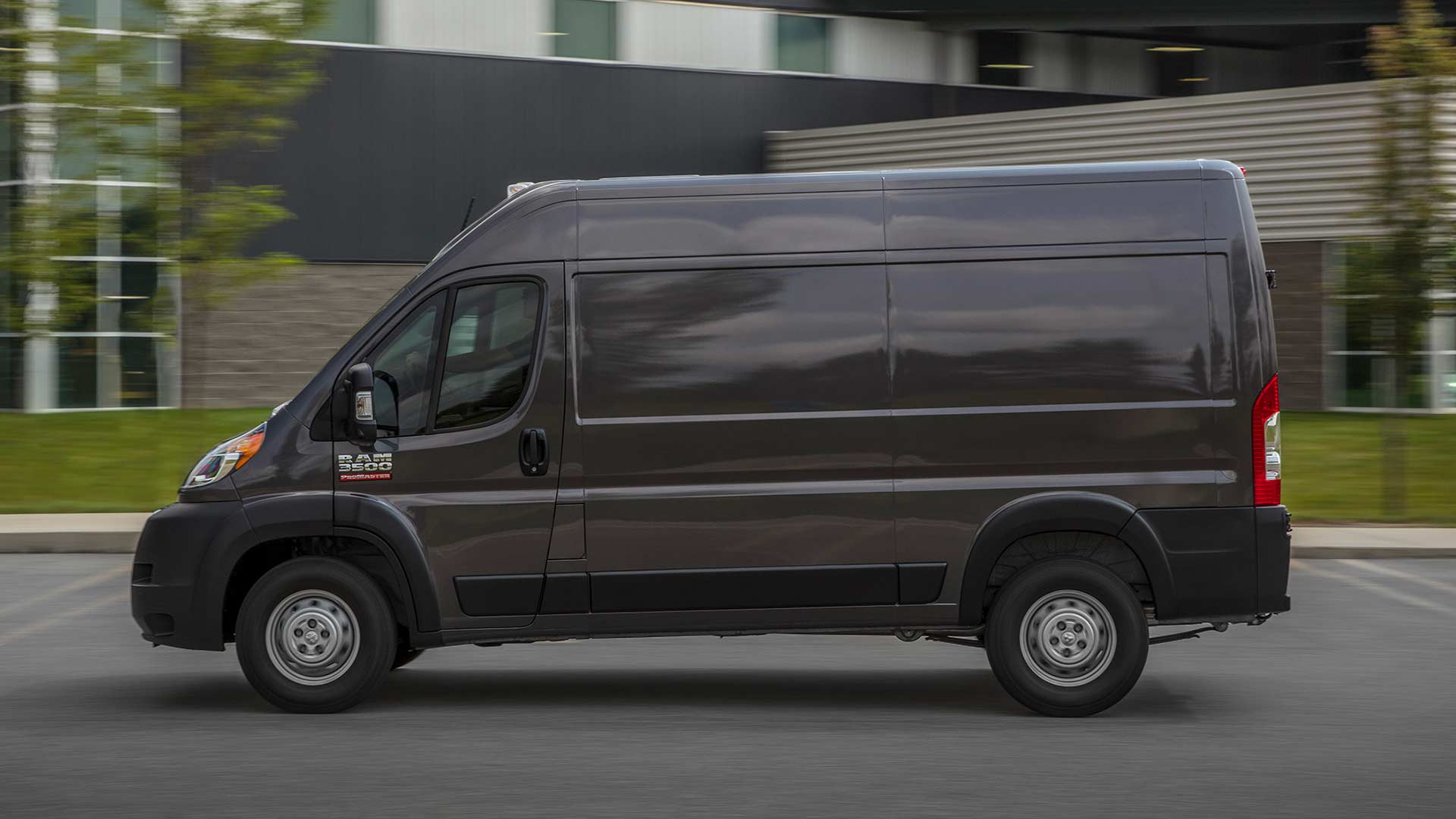 Display A side profile of a 2022 Ram ProMaster being driven on a residential street.