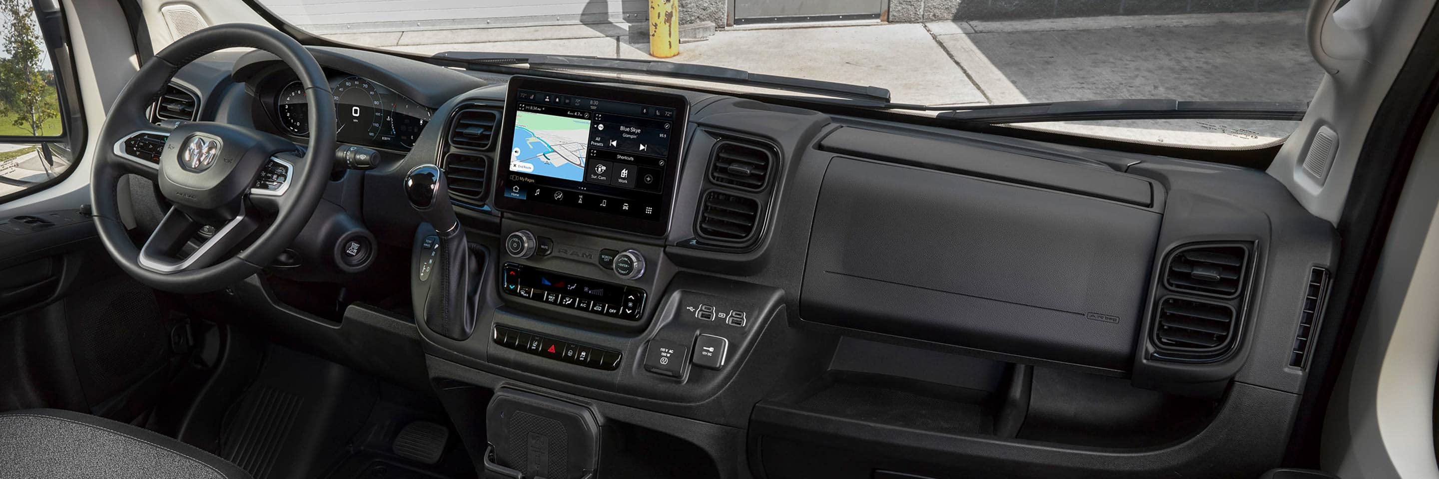 The interior of the 2022 Ram ProMaster, focusing on the steering wheel, dashboard and Uconnect touchscreen displaying a route map.