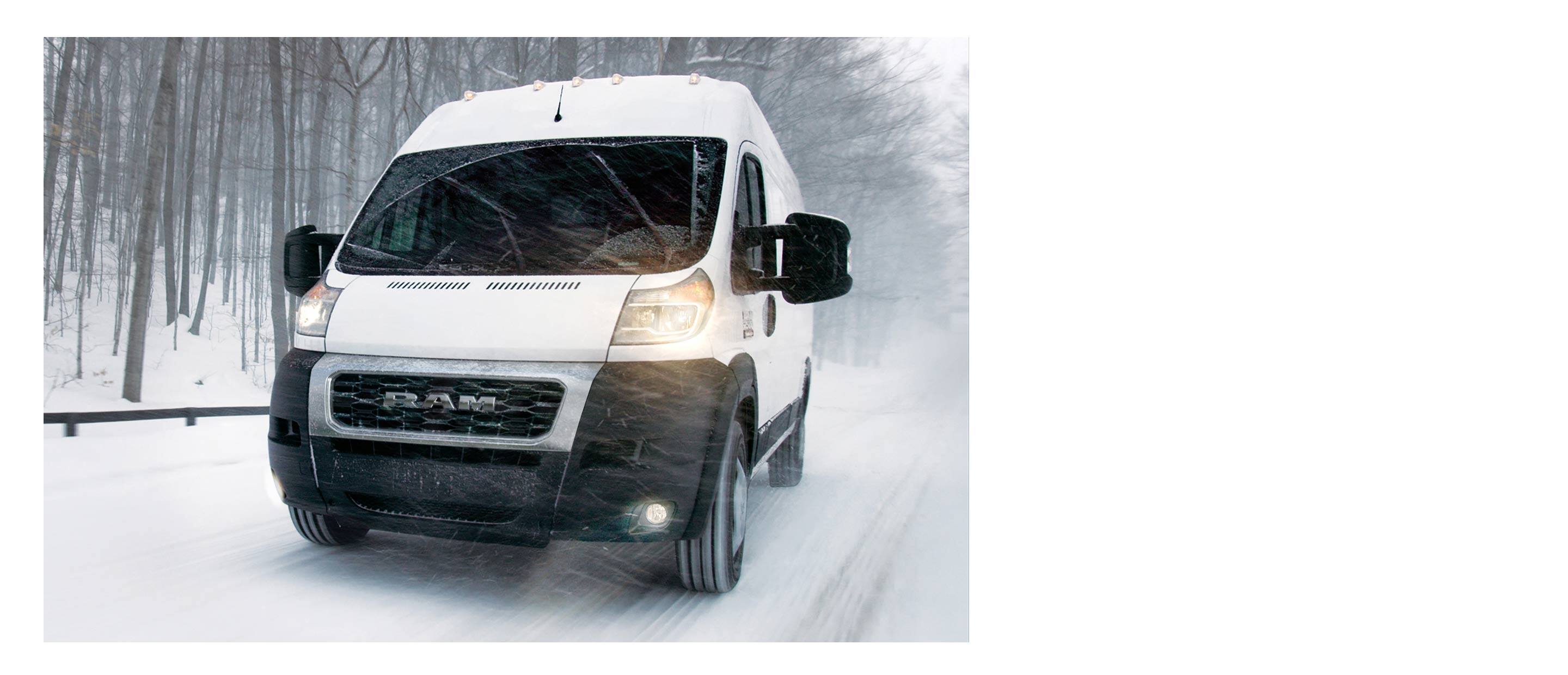 The 2022 Ram ProMaster being driven through blowing snow with its wipers activated.