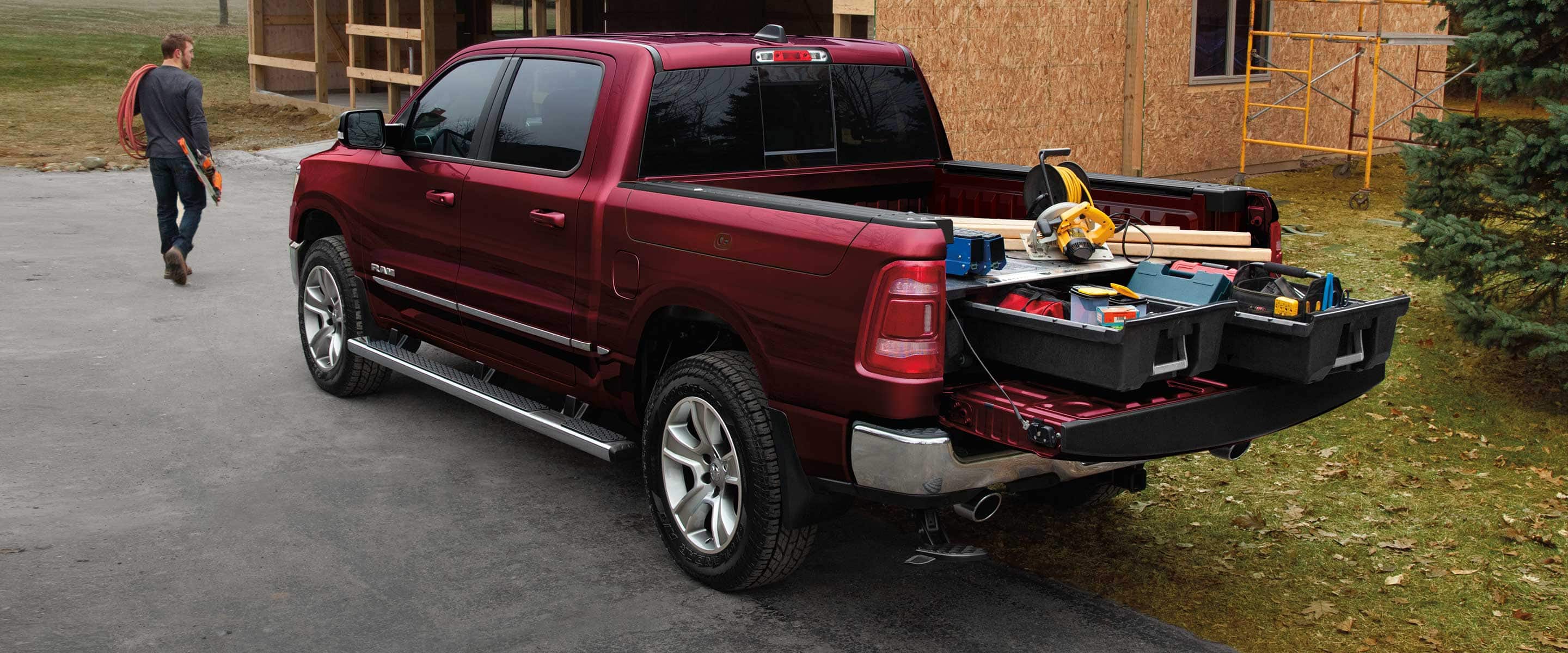 The Ram 1500 with its tailgate down to reveal the truck bed upfitted with slide-out drawers filled with tools and construction equipment.