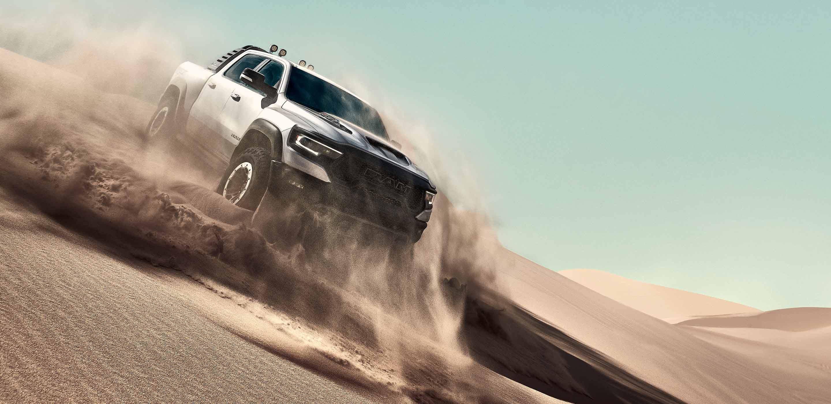The 2022 Ram TRX being driven on sandy terrain.