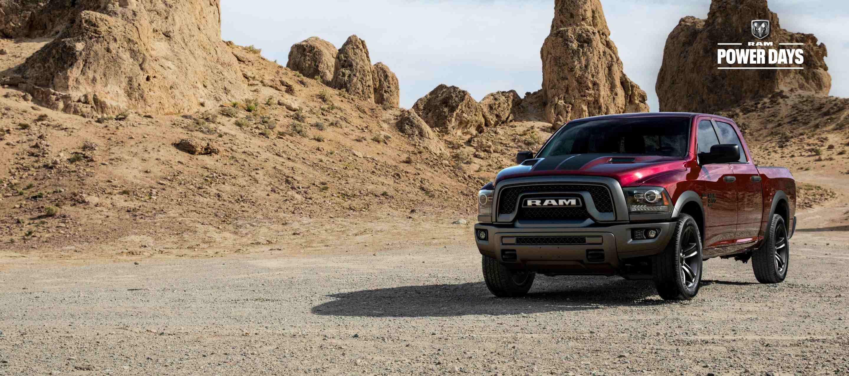 The 2023 Ram 1500 Classic parked on a twisting desert road with rocky outcroppings in the distance. Power Days Sales Event.