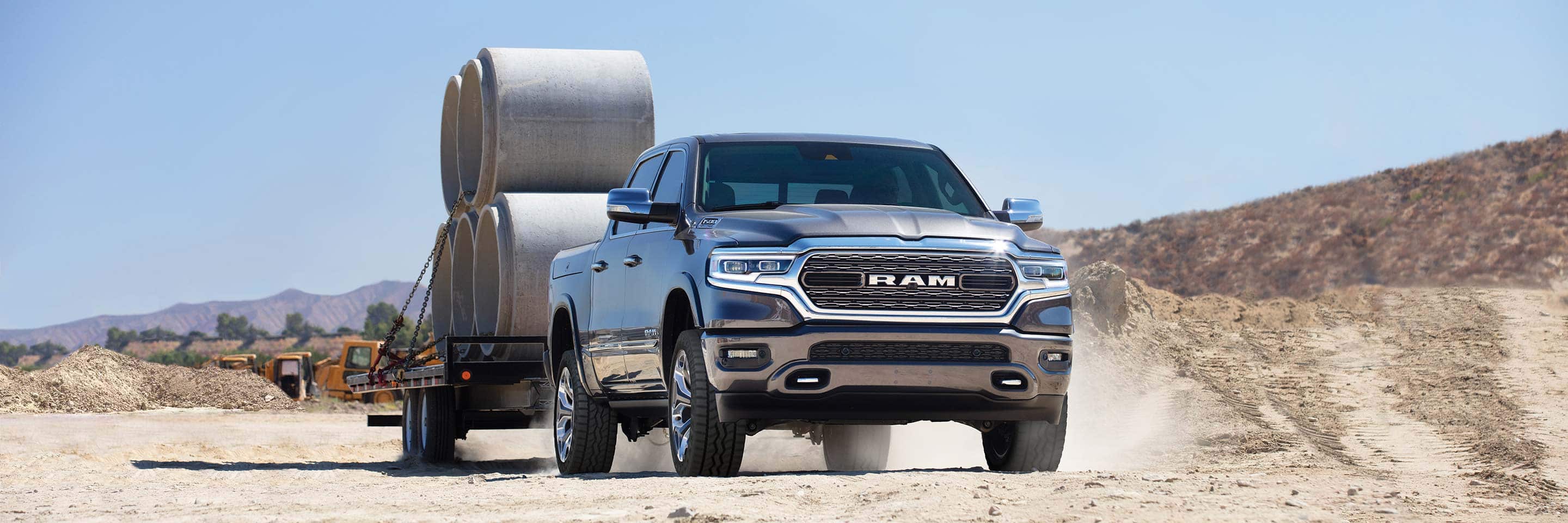 The 2023 Ram 1500 towing a trailer with cement forms on it.