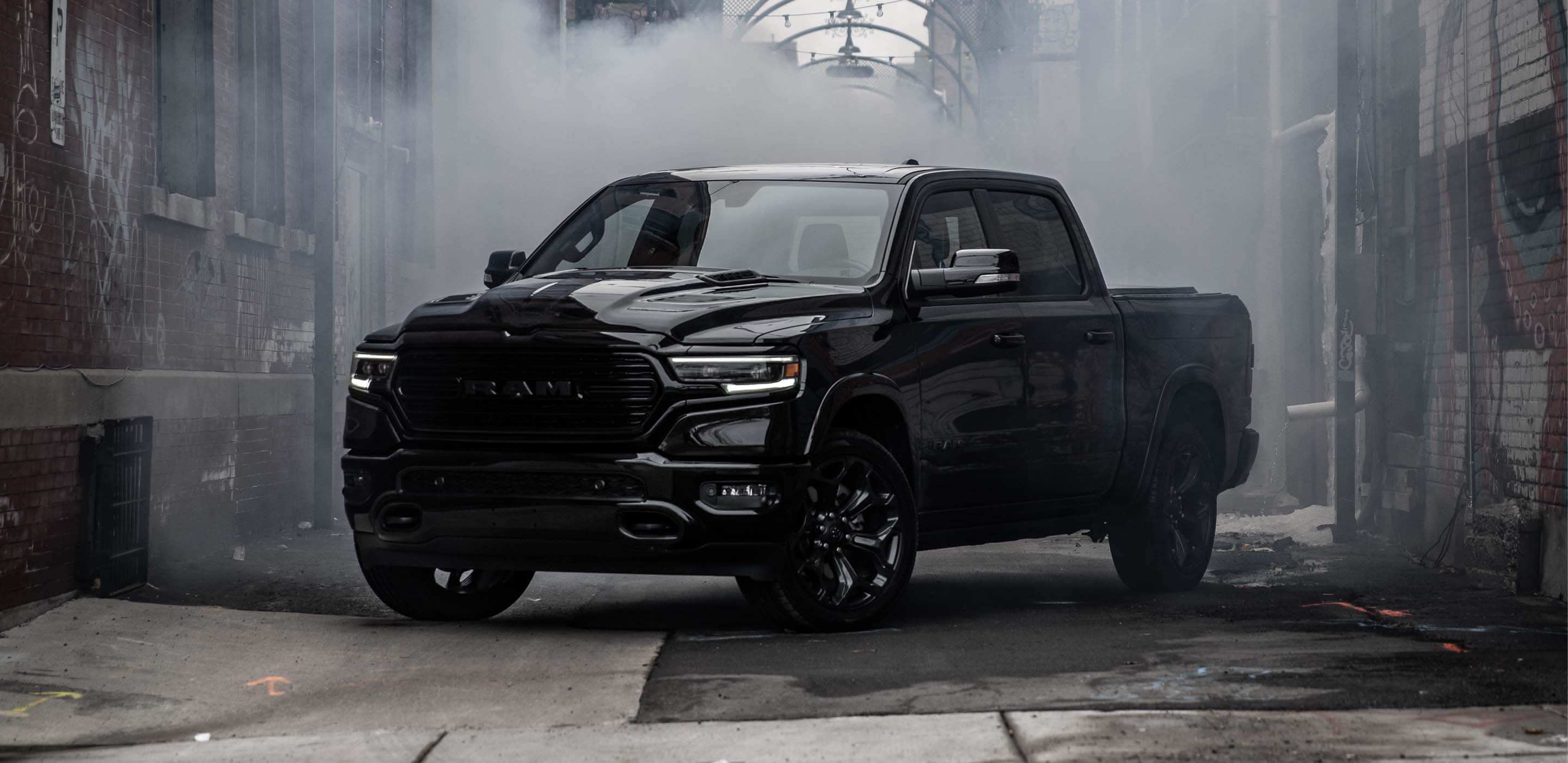 Display The 2023 Ram 1500 parked in a graffitied alleyway, surrounded by fog.