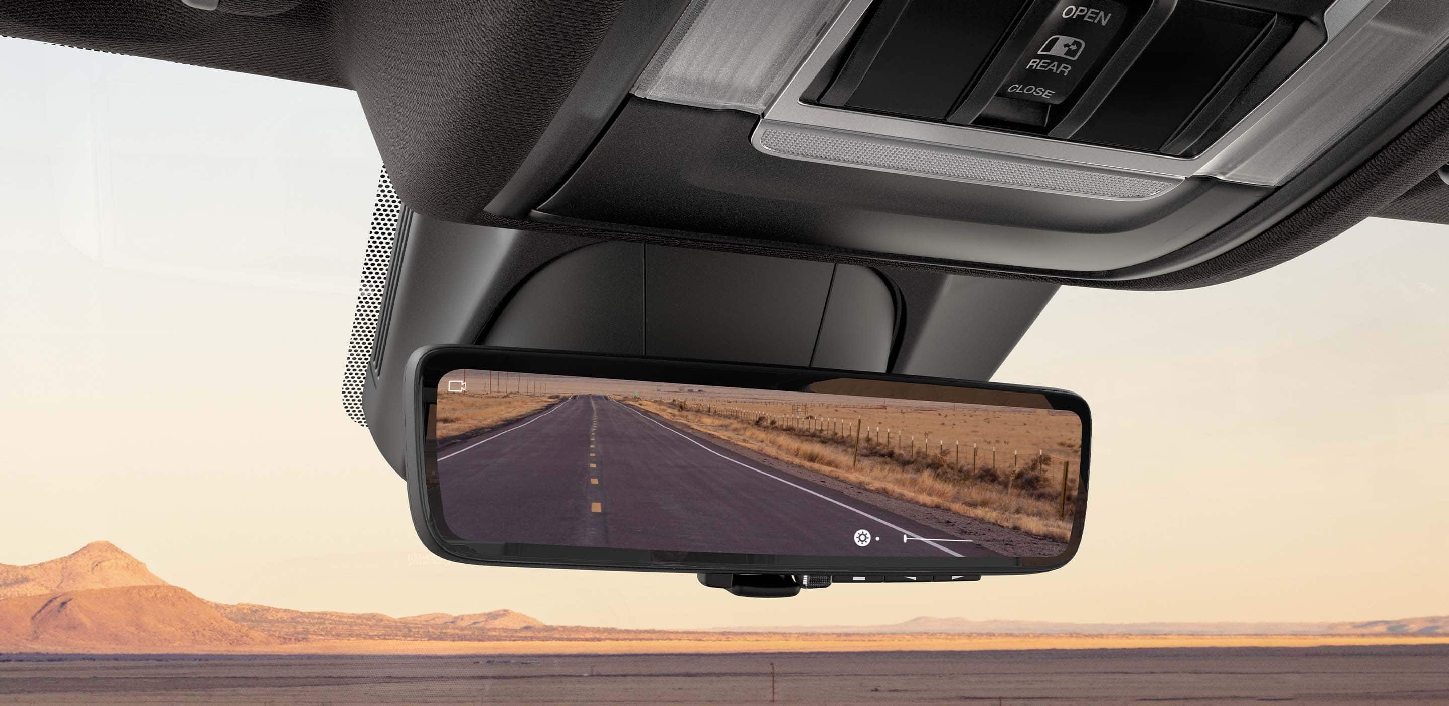 A close-up of the digital rearview mirror in the 2023 Ram 1500 with an empty road behind the vehicle.