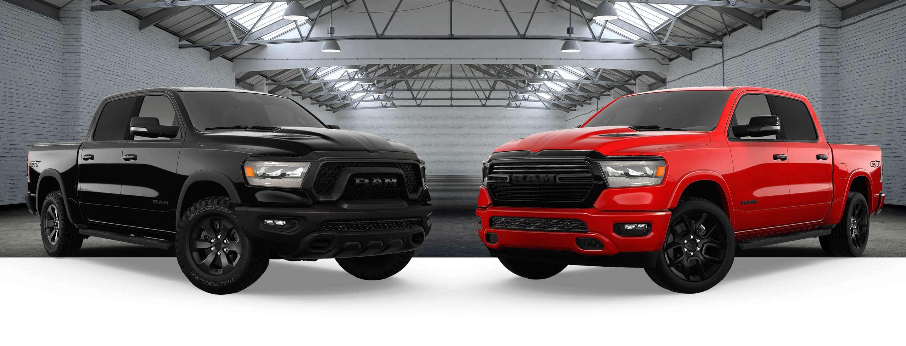 A black 2023 Ram 1500 Rebel G/T Crew Cab and a red 2023 Ram 1500 Laramie G/T Crew Cab with the backdrop of a large exhibition space.