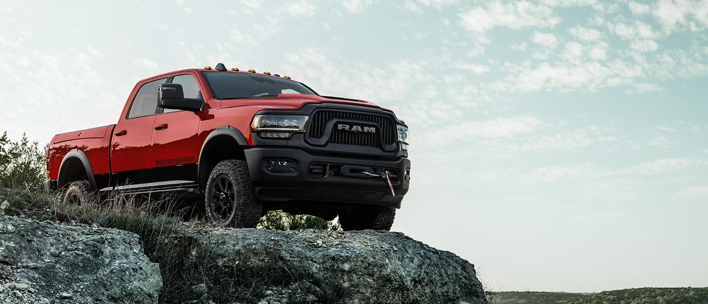 A red 2023 Ram 2500 Power Wagon Crew Cab parked on the edge of a cliff.
