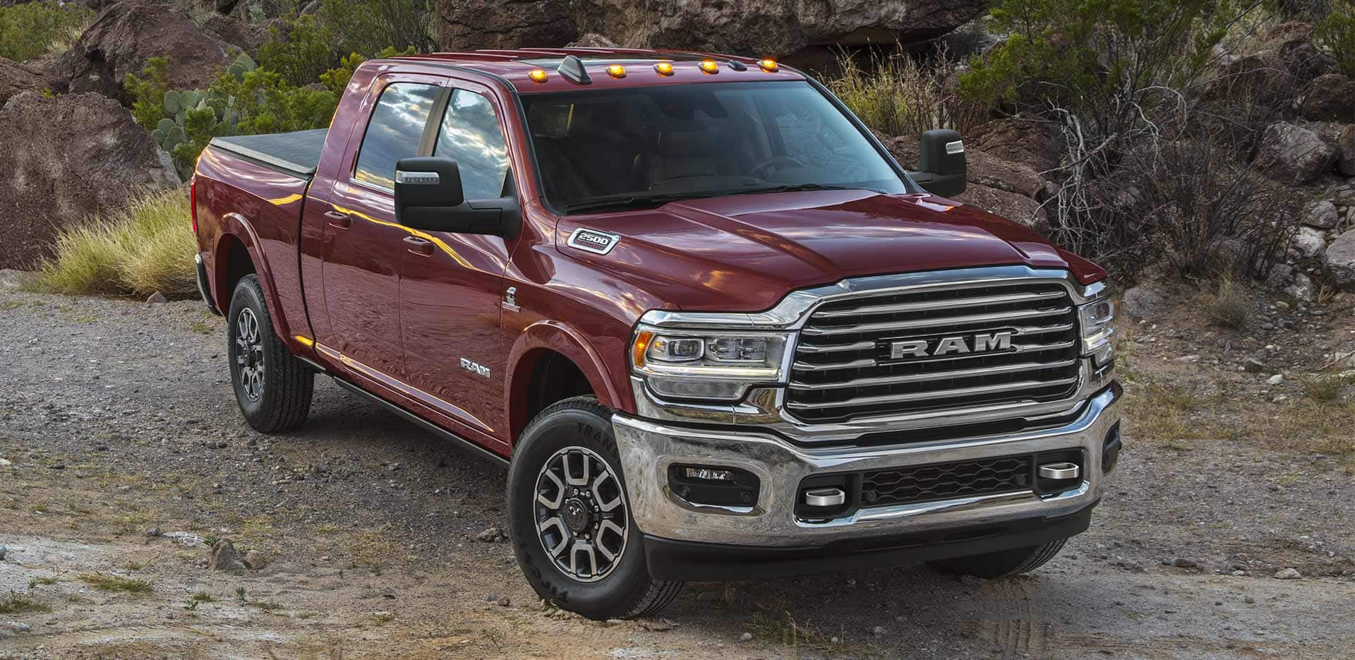 Display A red 2023 Ram 2500 Limited Longhorn Crew Cab parked on a clearing off-road.