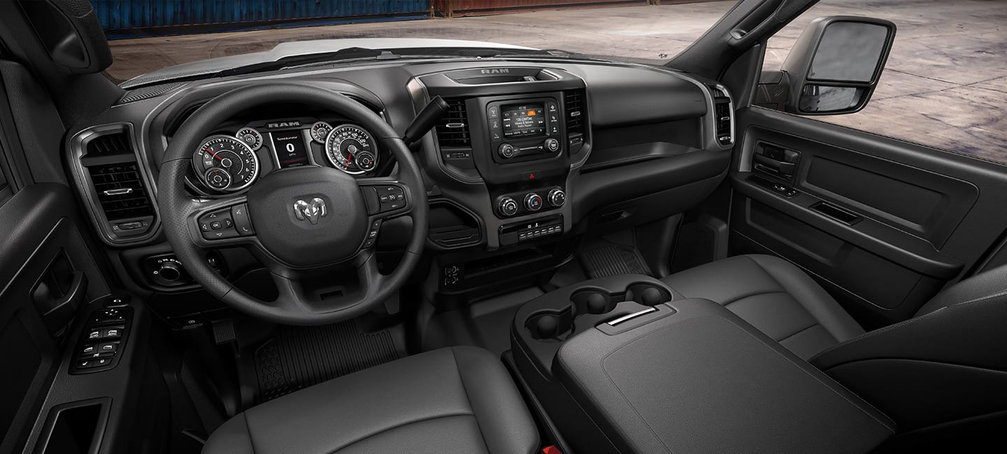 The interior of the 2023 Ram Tradesman Chassis Cab, the first of four selectable trim interiors, focusing on the steering wheel, touchscreen, center stack controls, dash, front seats and center console.