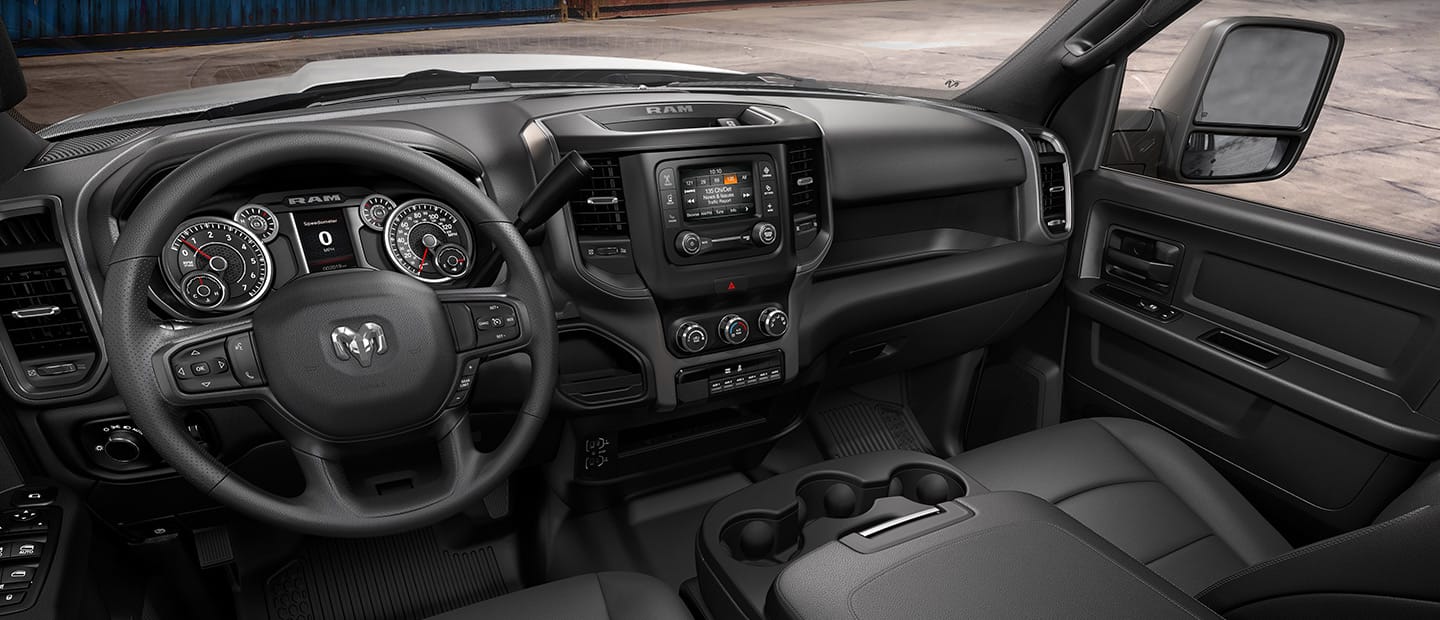 The interior of the 2023 Ram Chassis Cab, focusing on the steering wheel, touchscreen, center stack controls and dash.