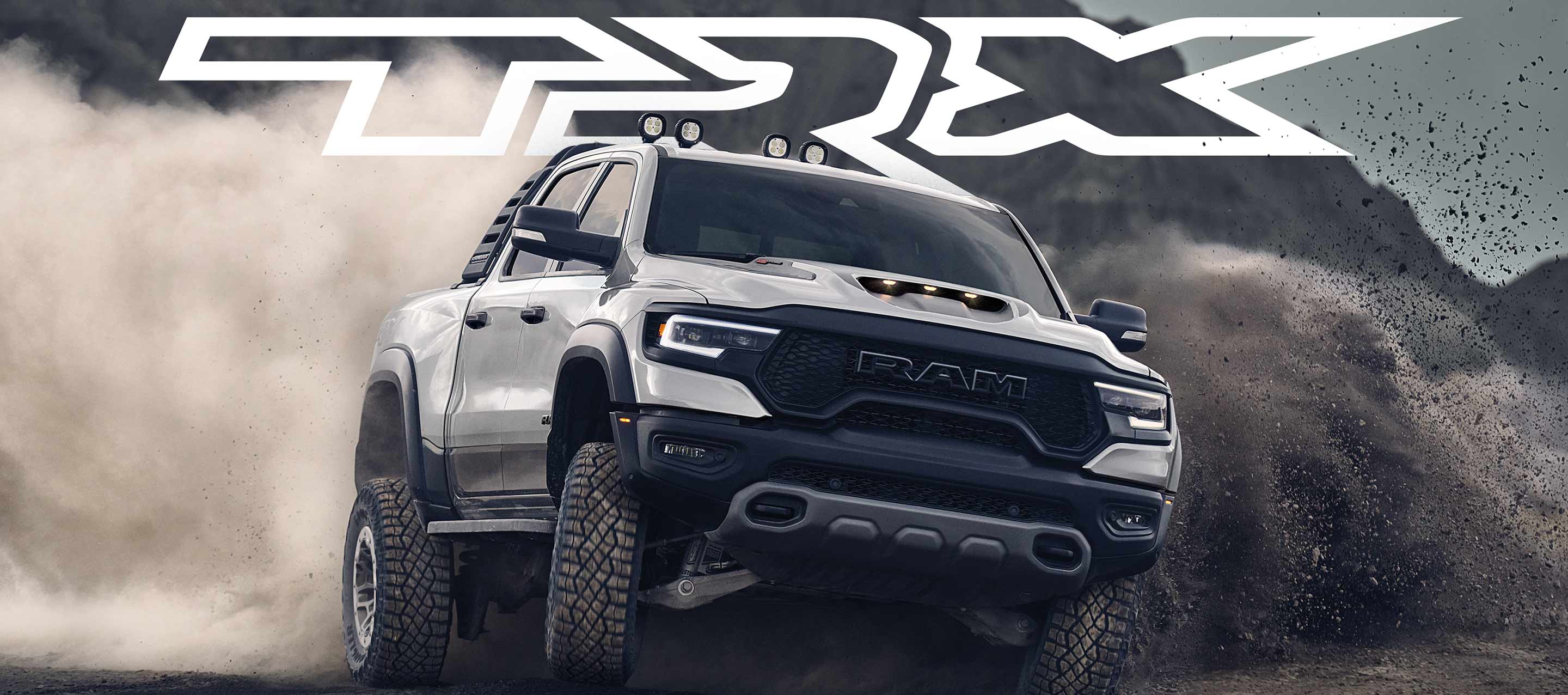 TRX. The 2023 Ram 1500 TRX being driven off-road with a cloud of loose dirt being churned up from its wheels.