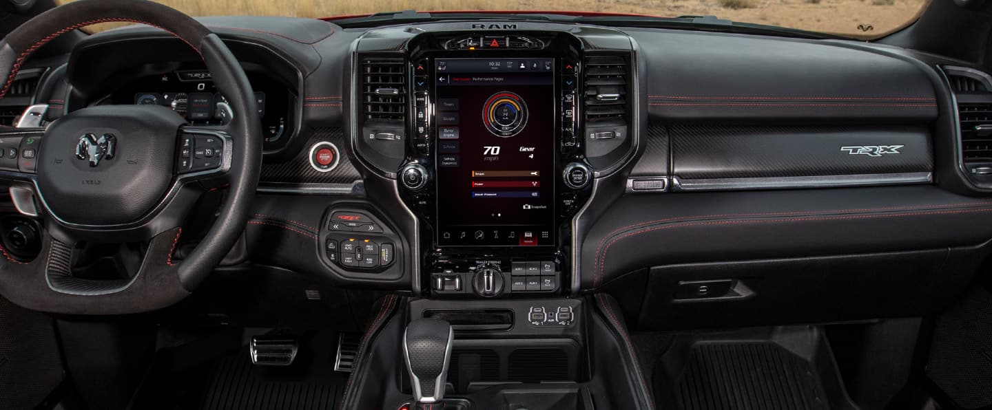 The interior of the 2023 Ram 1500 TRX with the Uconnect touchscreen on the Settings page.