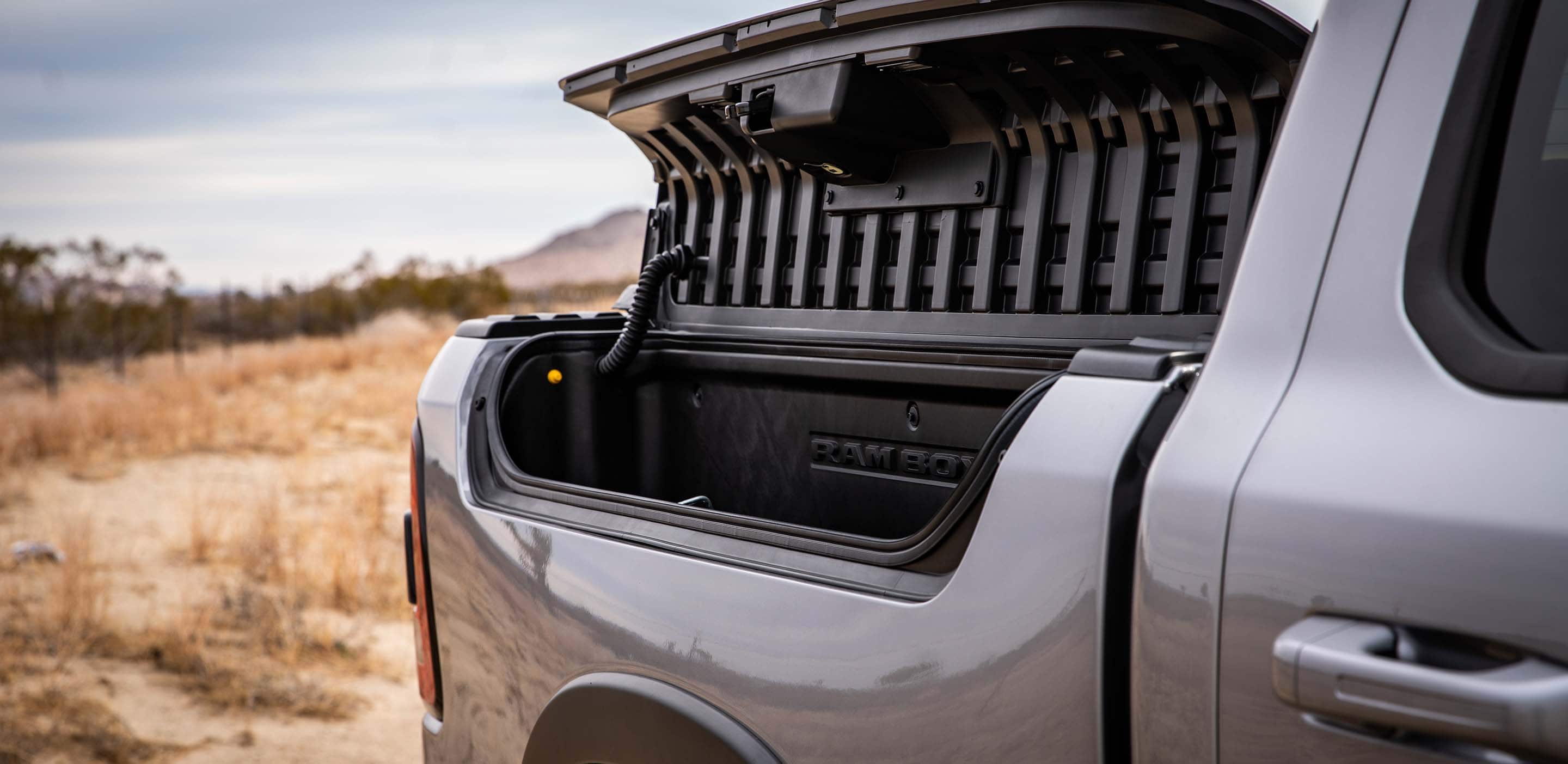 Display A close-up of the RamBox Cargo Management System on the side of the truck bed on a silver 2024 Ram 1500 Rebel with its lid open.