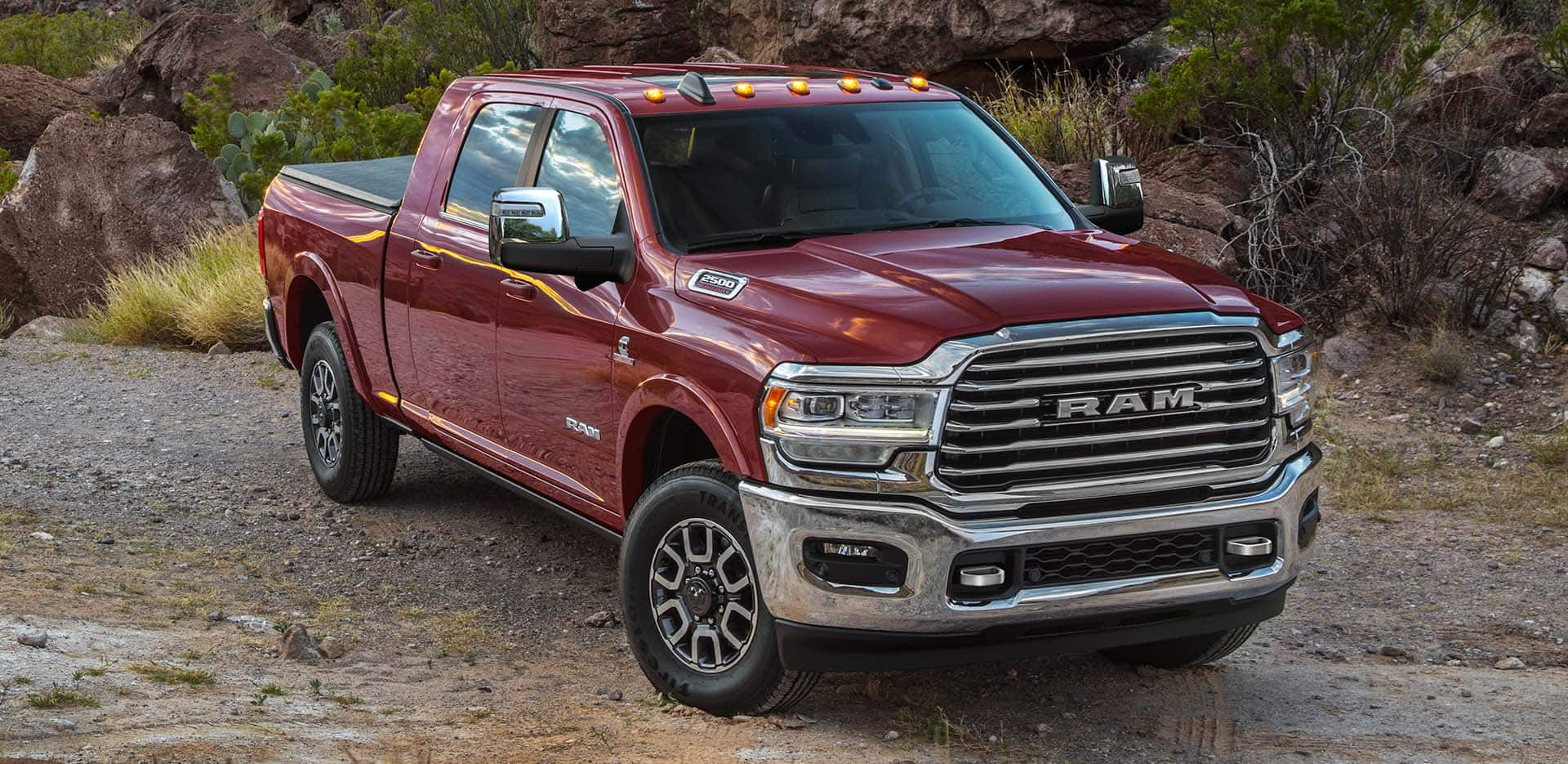 Display A red 2024 Ram 2500 Limited Longhorn Crew Cab parked on a clearing off-road.