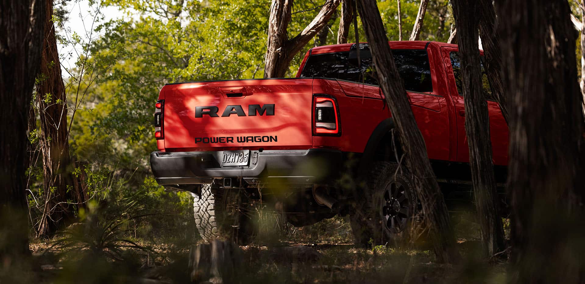 Tailgate of a red RAM 2024 2500 Power Wagon parked under a tree in a forest