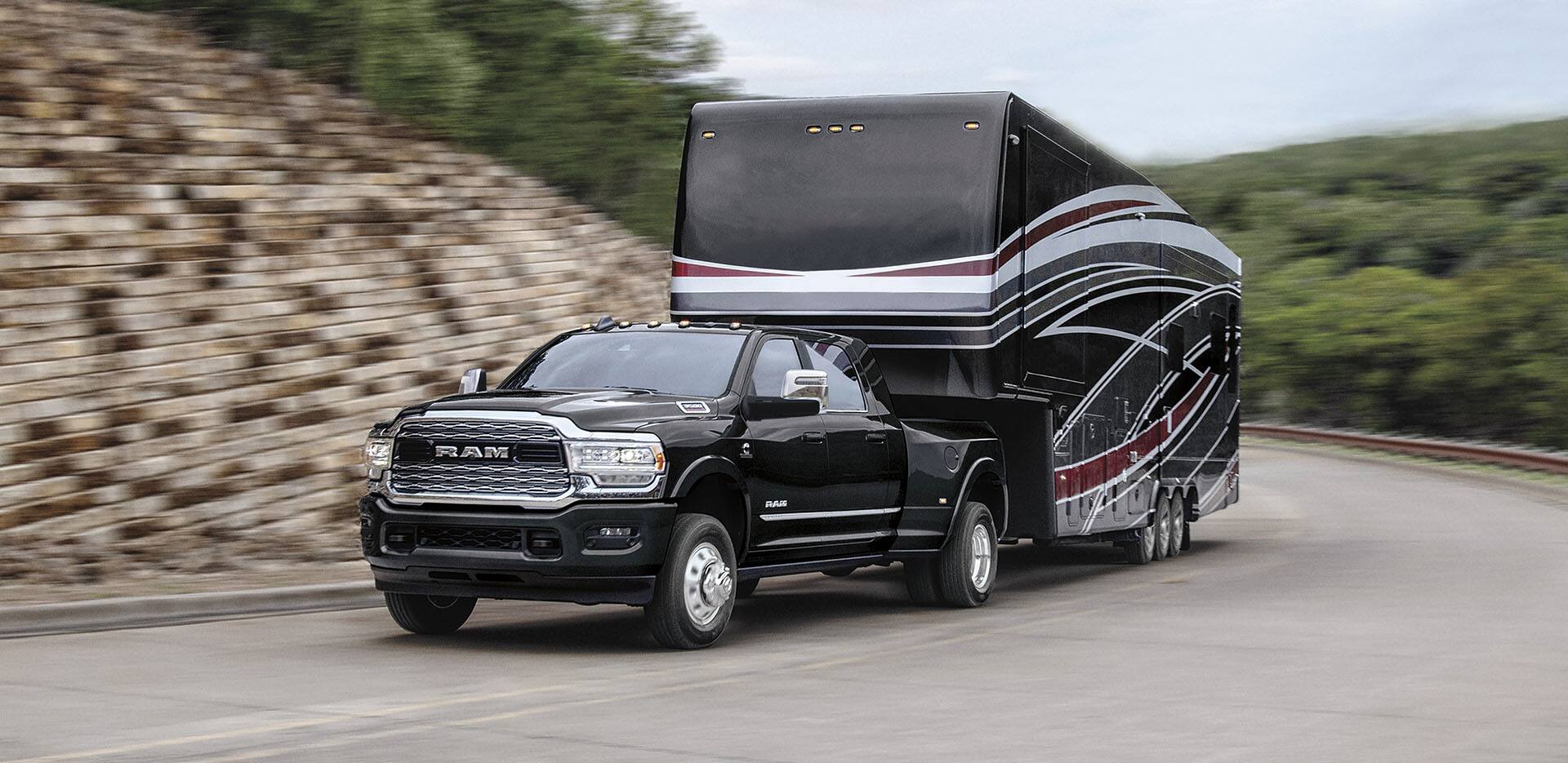 Black truck pulling a mobile home.