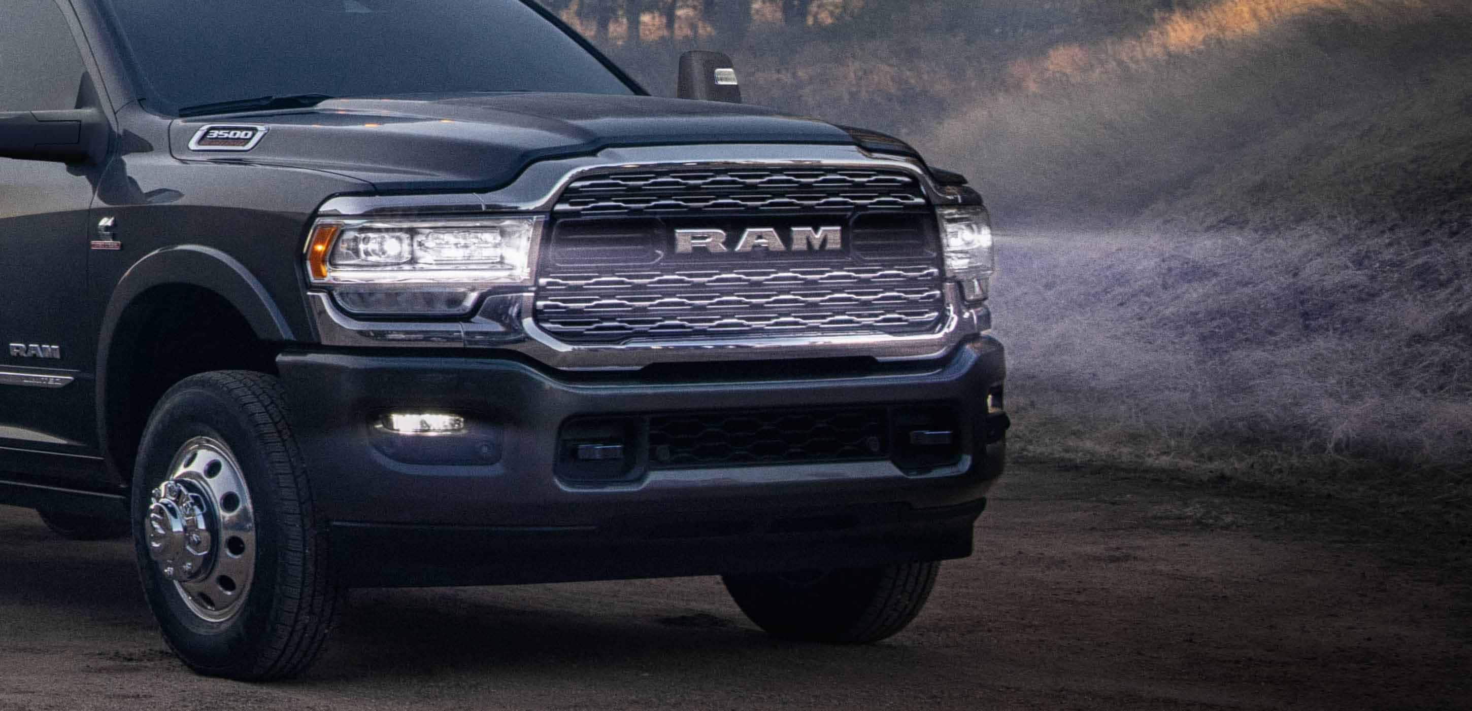 Display The front end of a 2024 Ram 3500 Limited Crew Cab Chassis Cab with its LED headlamps on, illuminating the road ahead.