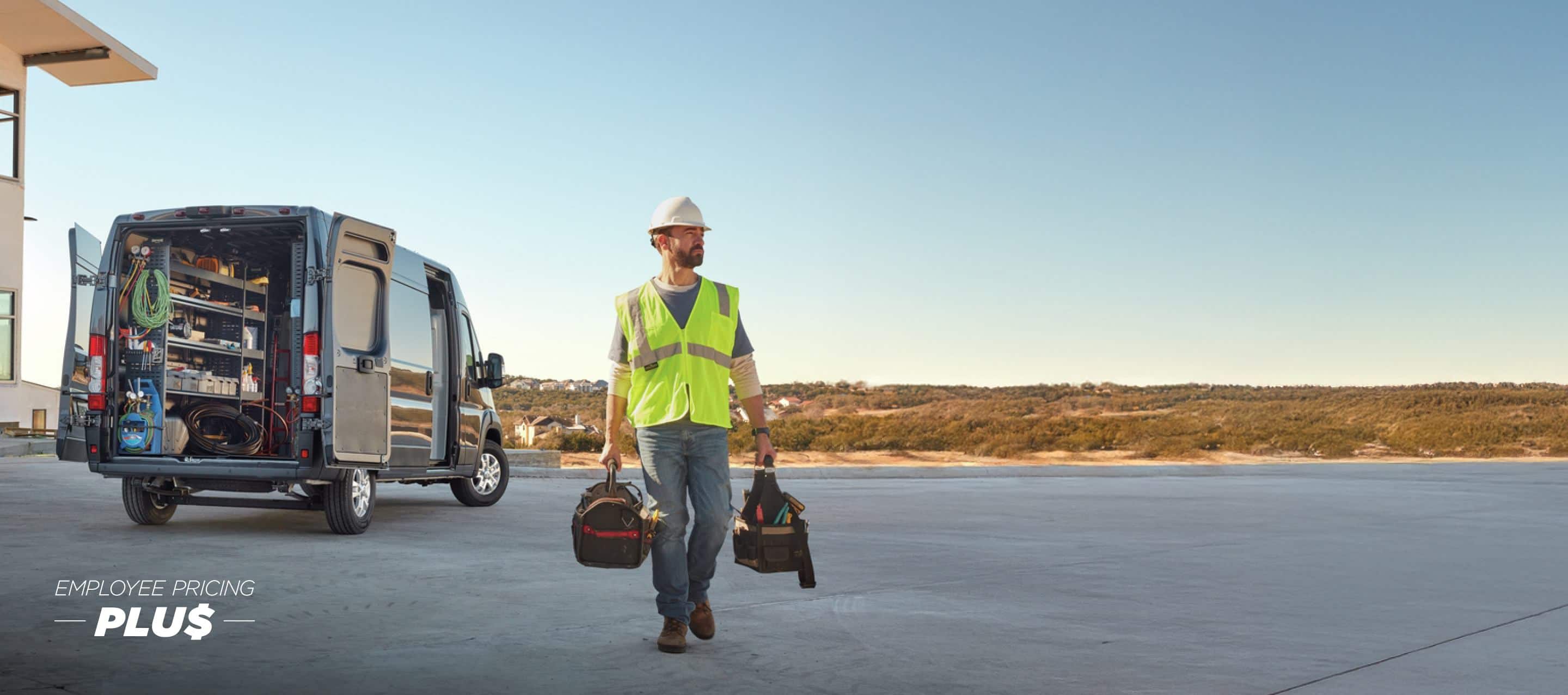 The rear of a gray 2024 Ram ProMaster 3500 SLT Plus High Roof Cargo Van with its passenger-side sliding door and rear doors open, displaying shelves full of tools and a technician walking away from the vehicle. Employee Pricing Plus Sales Event.