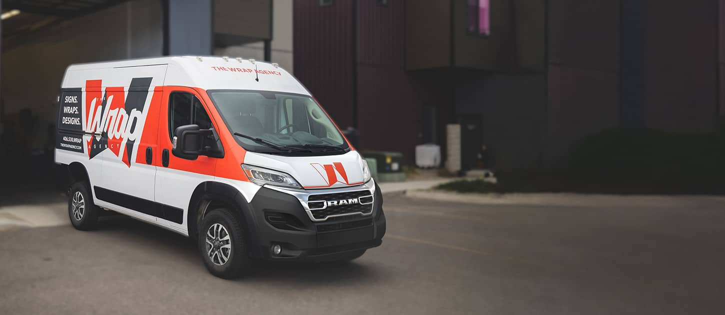  An angled passenger-side profile of a 2024 Ram ProMaster 2500 SLT Cargo Van High Roof, with a custom paint job in white and red, and company signage on the side panel.