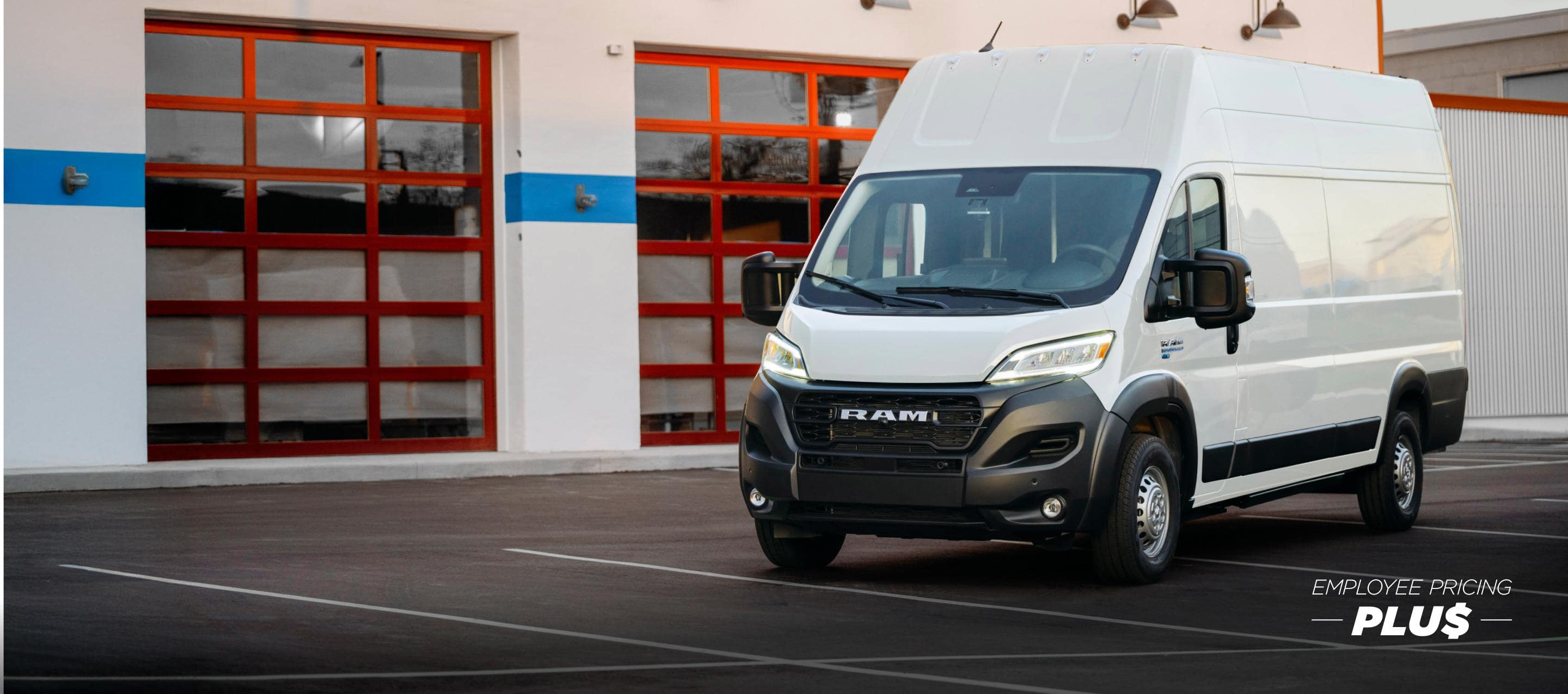 A driver-side front angle of a white 2024 Ram ProMaster EV 3500 Super High Roof Step Van parked near a commercial garage. Employee Pricing Plus Sales Event.