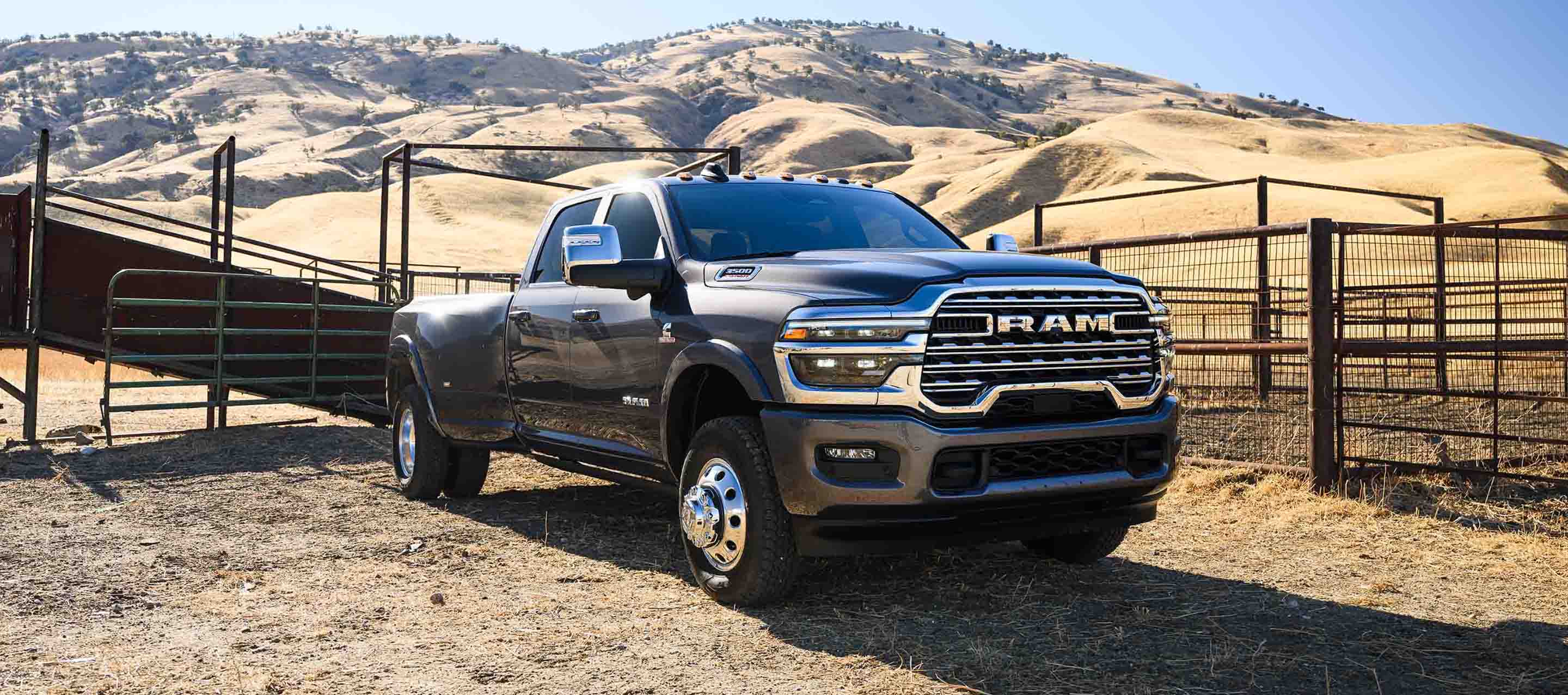 A black 2025 Ram 3500 Limited Longhorn 4x4 Crew Cab parked at a ranch in the desert.