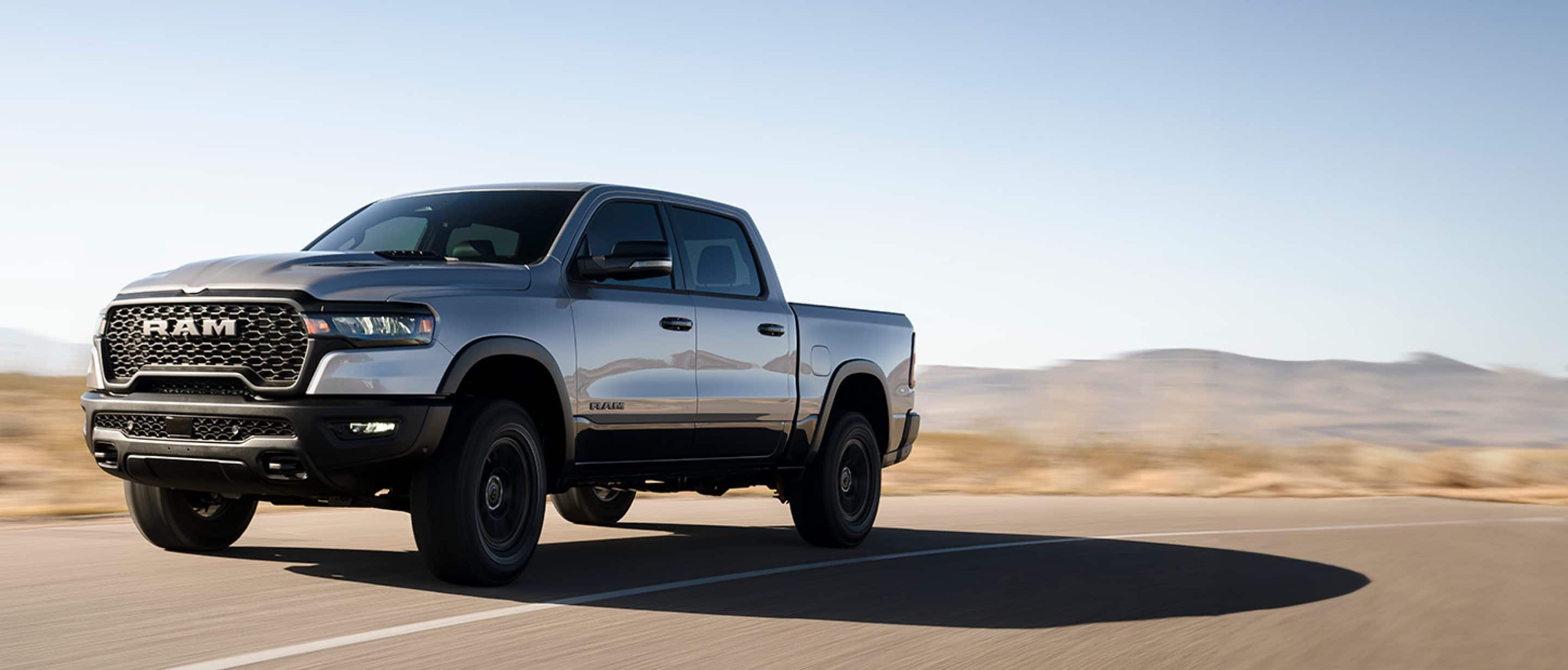 The 2025 Ram 1500 Rebel in Billet-Silver Metallic driving on desert road.