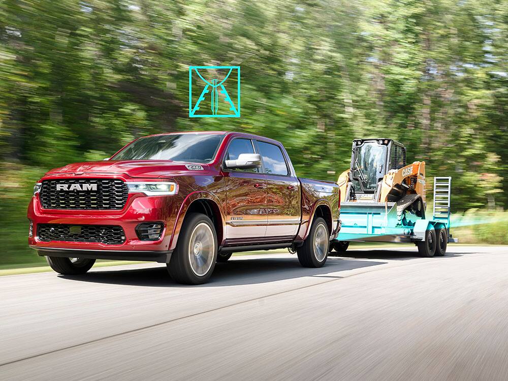The new 2025 Ram 1500 Laramie in Delmonico Red pearl towing compact skid steer equipment.