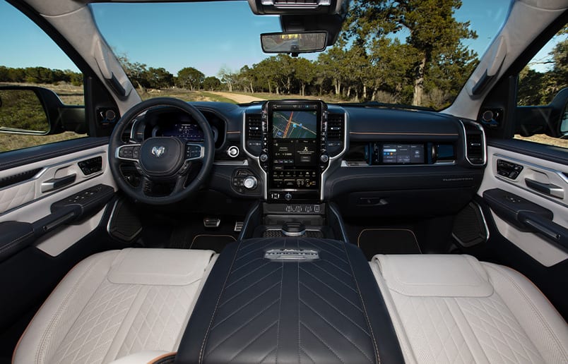 The steering wheel, Digital Cluster Display, Uconnect touchscreen and front Passenger Interactive Touchscreen Display in the 2025 Ram 1500 Tungsten.